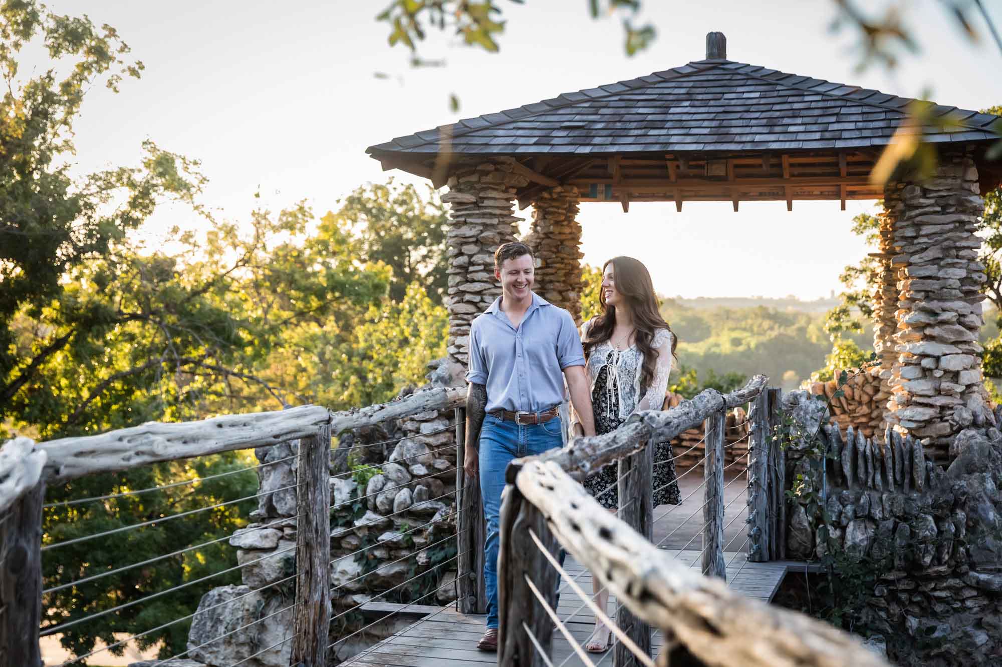 Couple walking in front of stone building on wooden platform during a Japanese Tea Garden engagement portrait 