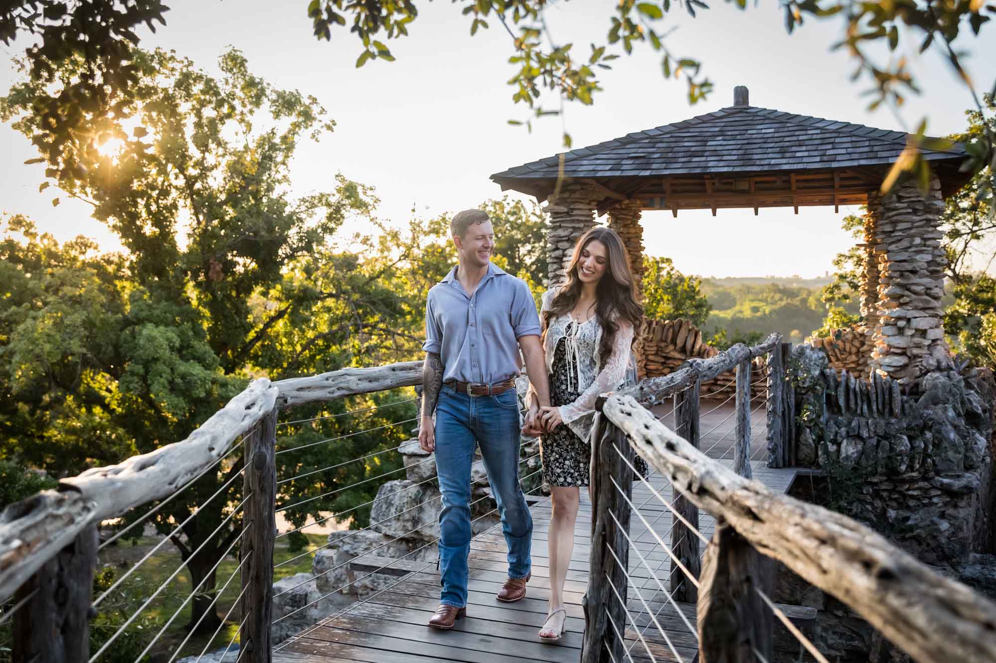 Couple walking in front of stone building on wooden platform during a Japanese Tea Garden engagement portrait 
