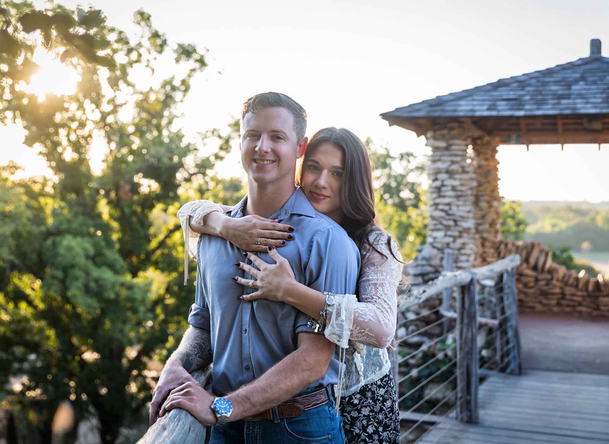 Couple hugging in front of stone building on wooden platform during a Japanese Tea Garden engagement portrait 