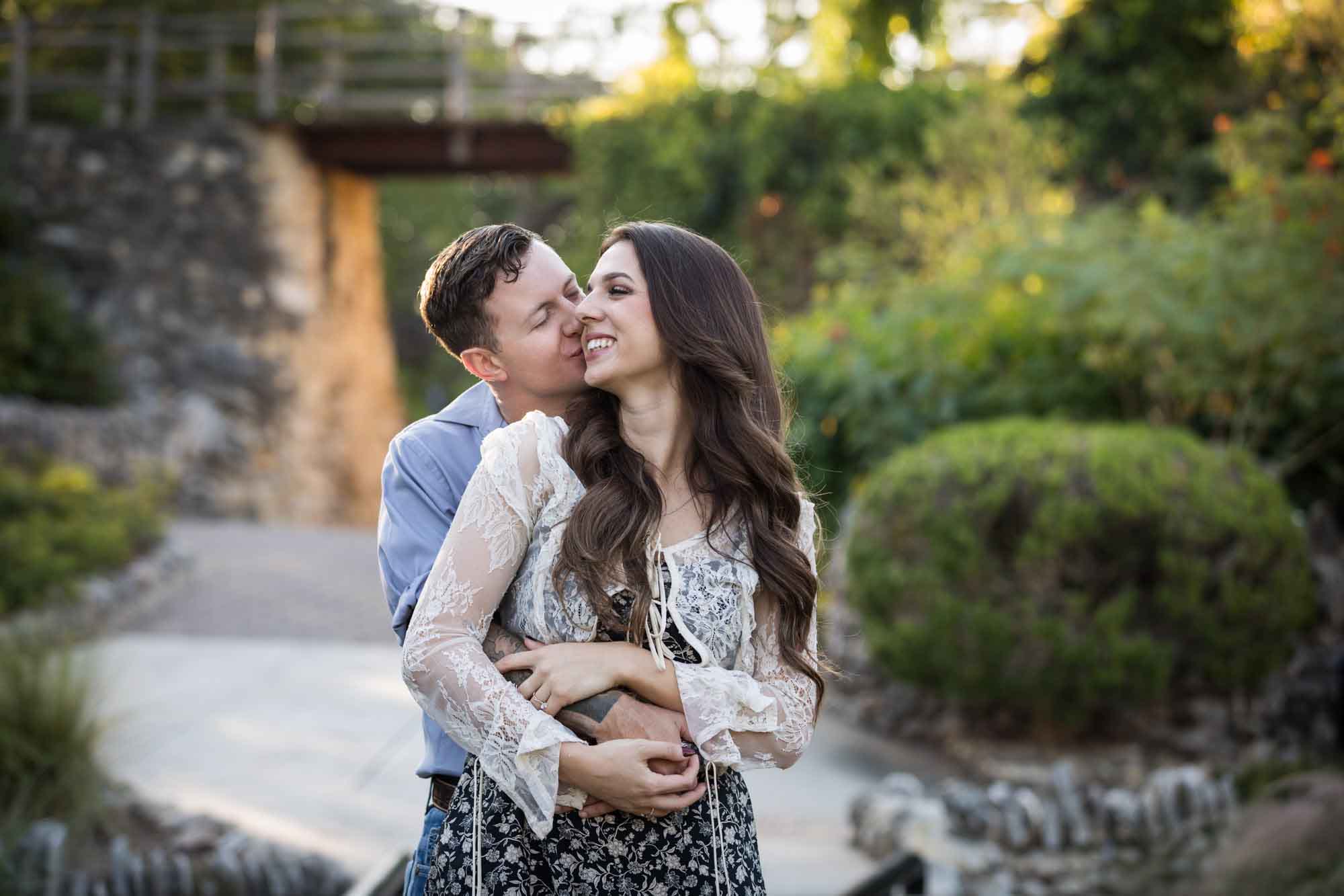 Couple kissing in the Japanese Tea Garden during an engagement shoot for an article on ‘Where do I Start with Wedding Planning?’