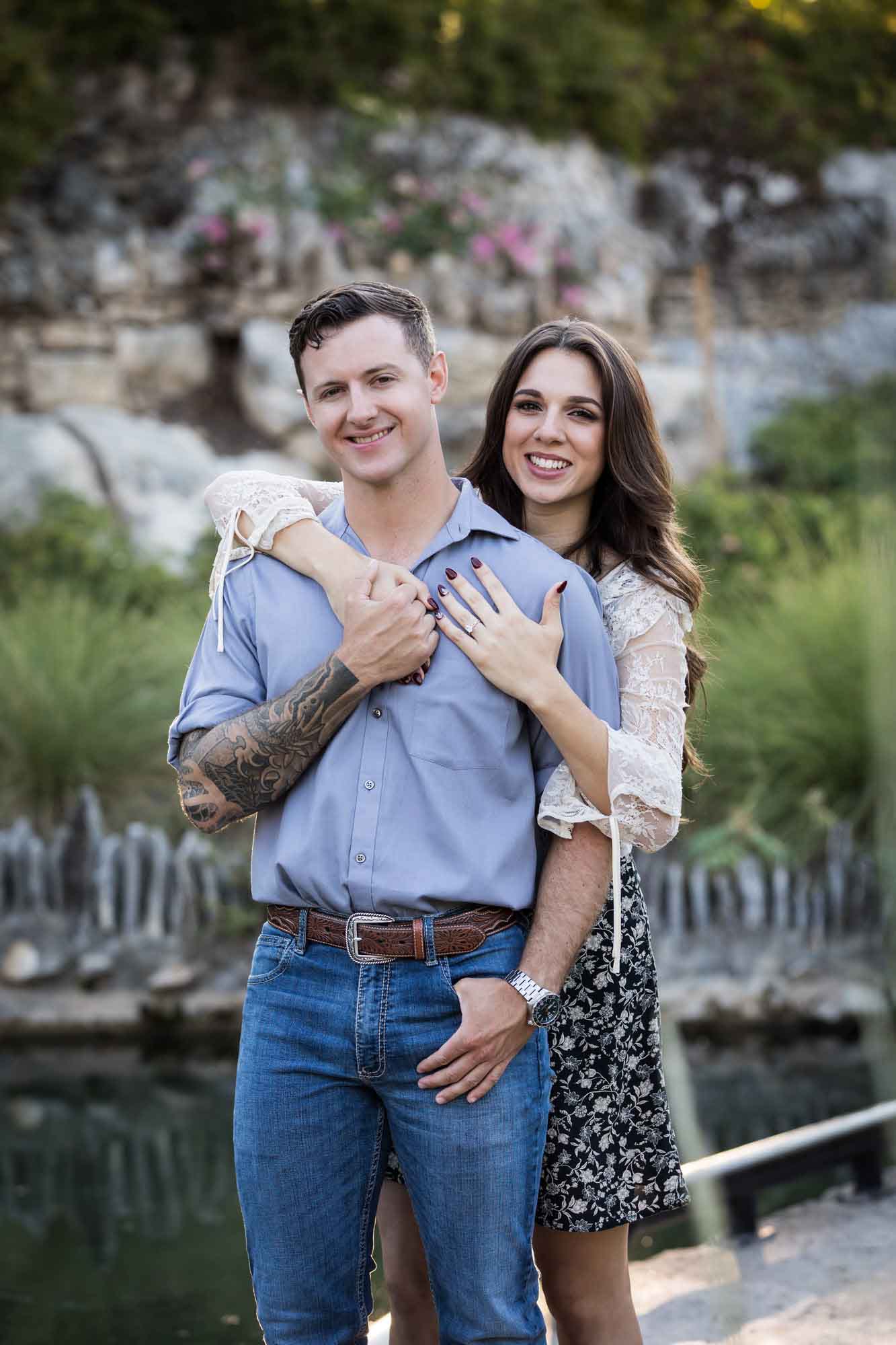 Woman hugging man from behind in the Japanese Tea Garden during an engagement shoot for an article on ‘Where do I Start with Wedding Planning?’