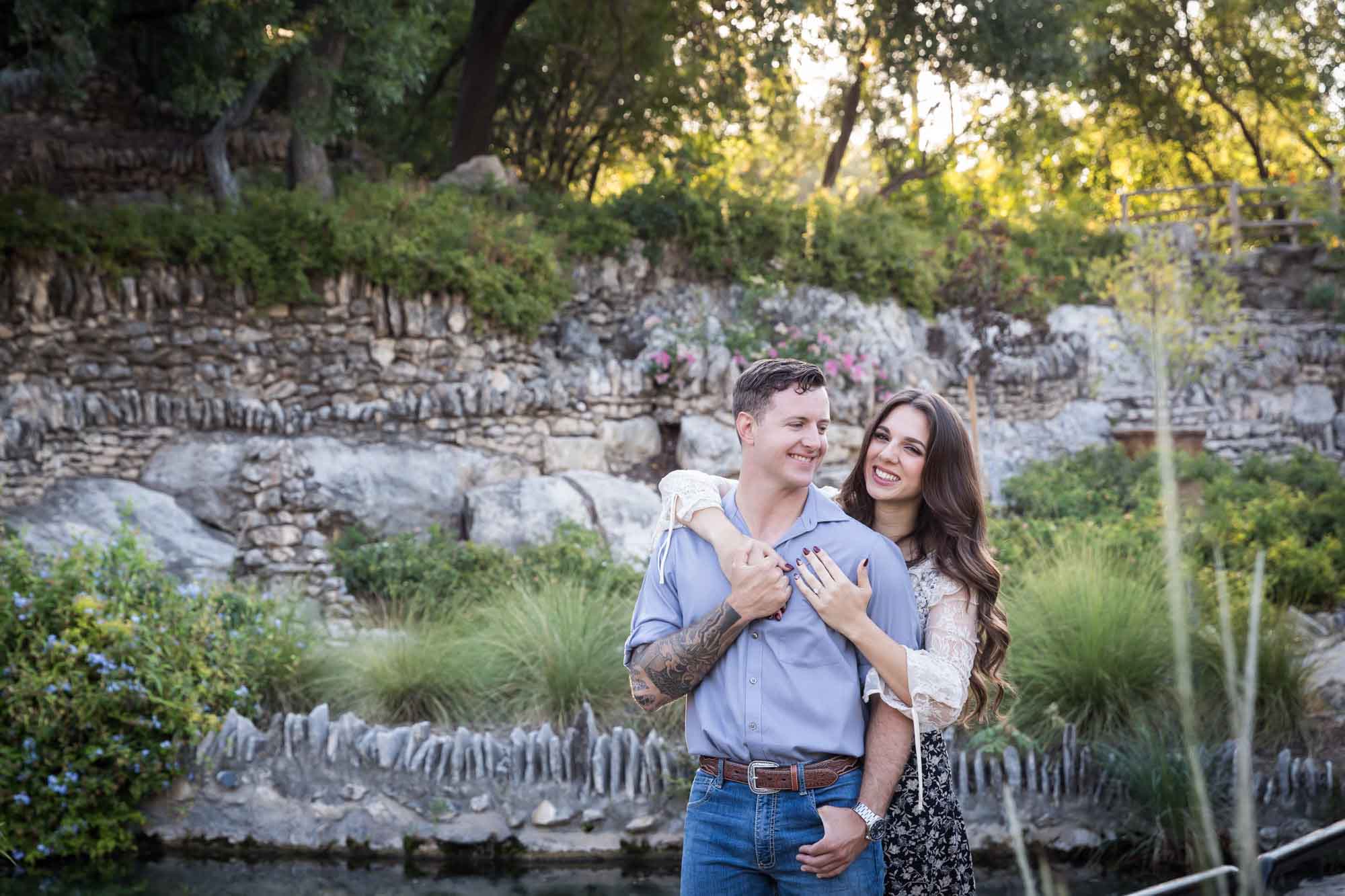 Woman hugging man from behind in the Japanese Tea Garden during an engagement shoot for an article on ‘Where do I Start with Wedding Planning?’