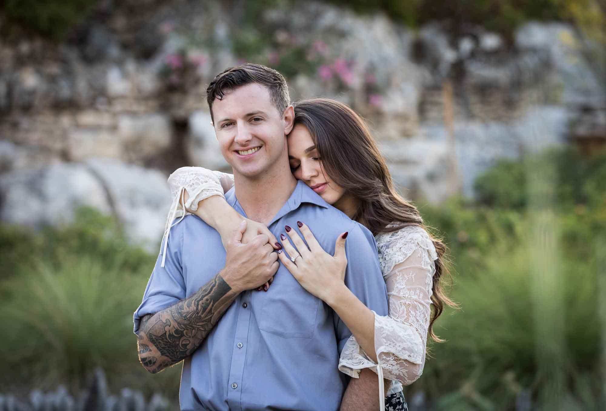 Woman hugging man from behind in the Japanese Tea Garden during an engagement shoot for an article on ‘Where do I Start with Wedding Planning?’