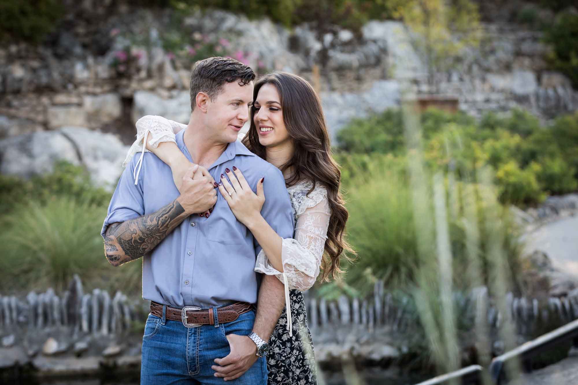 Woman hugging man from behind in the Japanese Tea Garden during an engagement shoot for an article on ‘Where do I Start with Wedding Planning?’