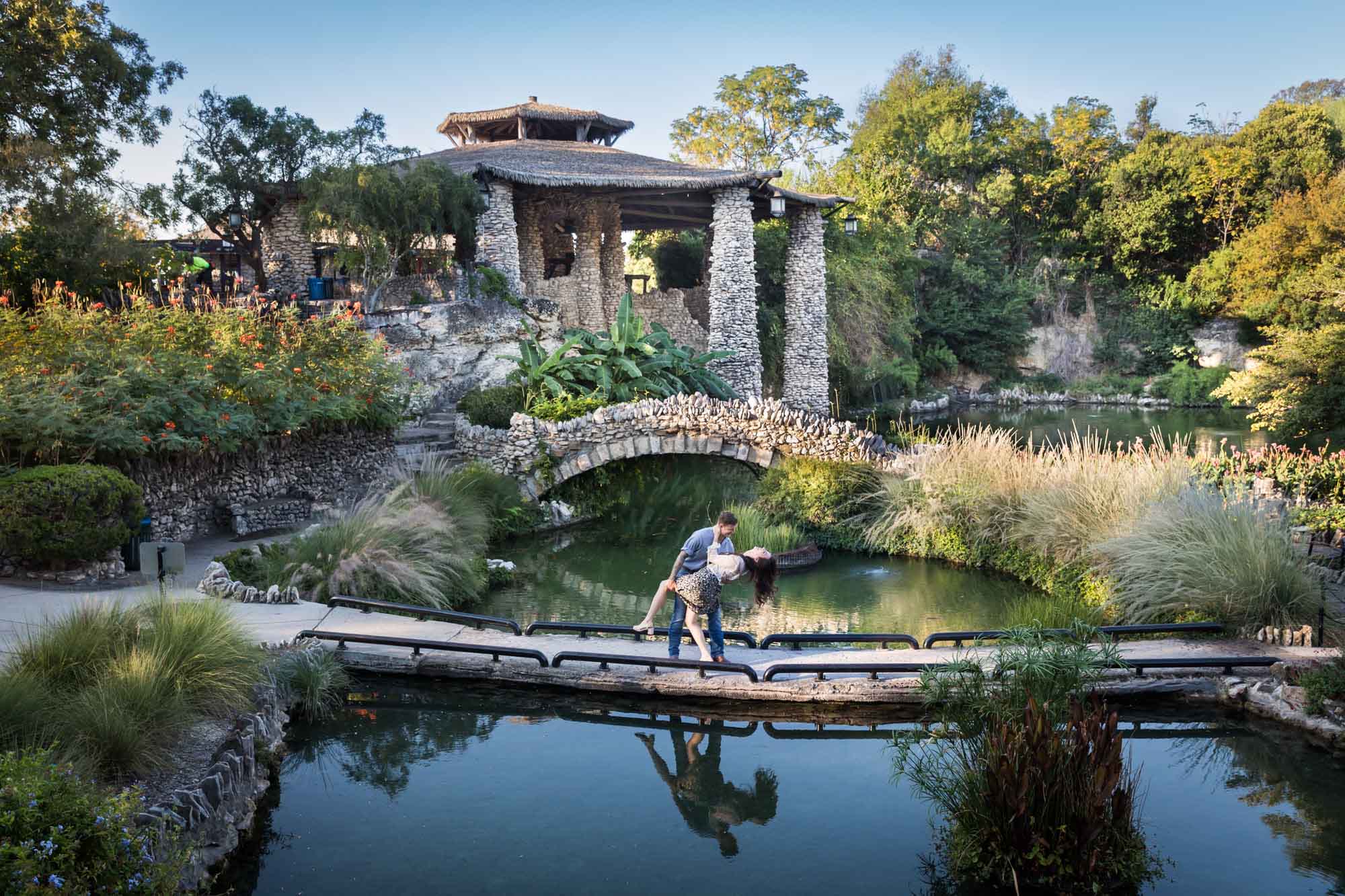 Couple dancing in pathway in front of pond in the Japanese Tea Garden during an engagement shoot for an article on ‘Where do I Start with Wedding Planning?’