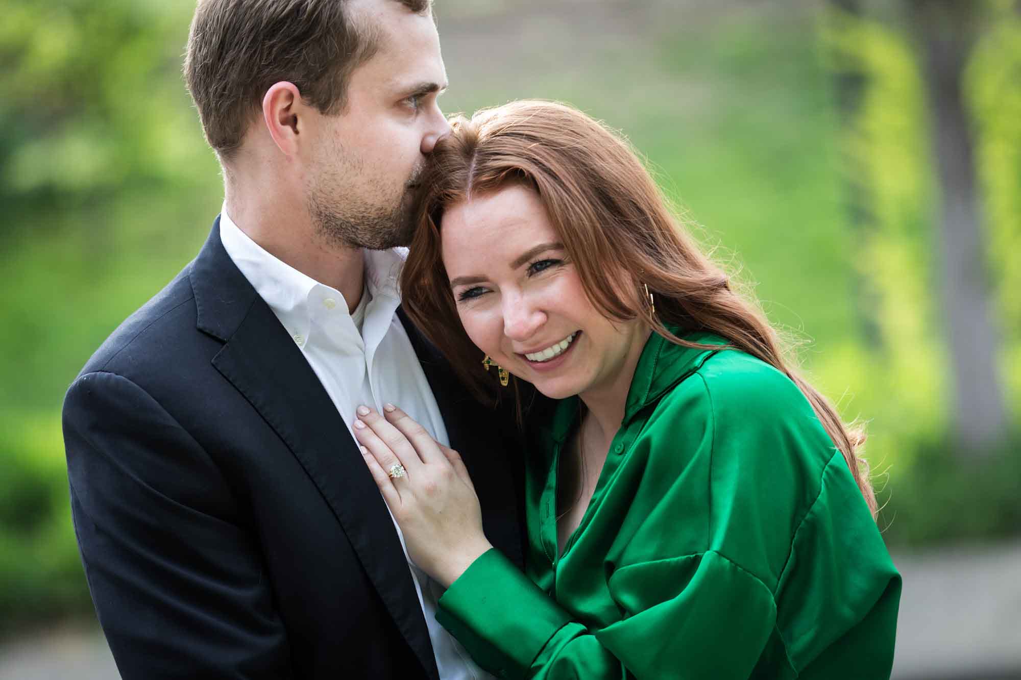 Man wearing black suit standing with woman wearing green blouse during an Emma Hotel surprise proposal