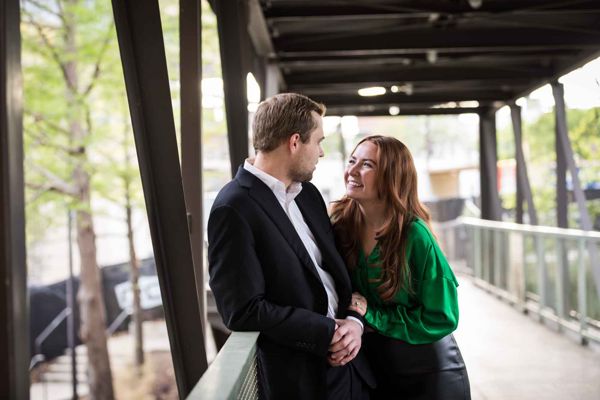 Man and laughing woman standing on bridge at the Pearl during an Emma Hotel engagement photo shoot