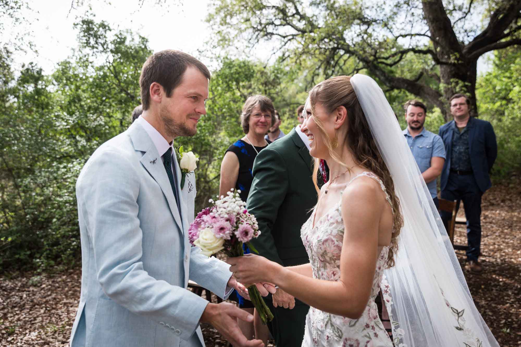 Bride and groom about to hug during ceremony during a Lady Bird Johnson Wildflower Center wedding