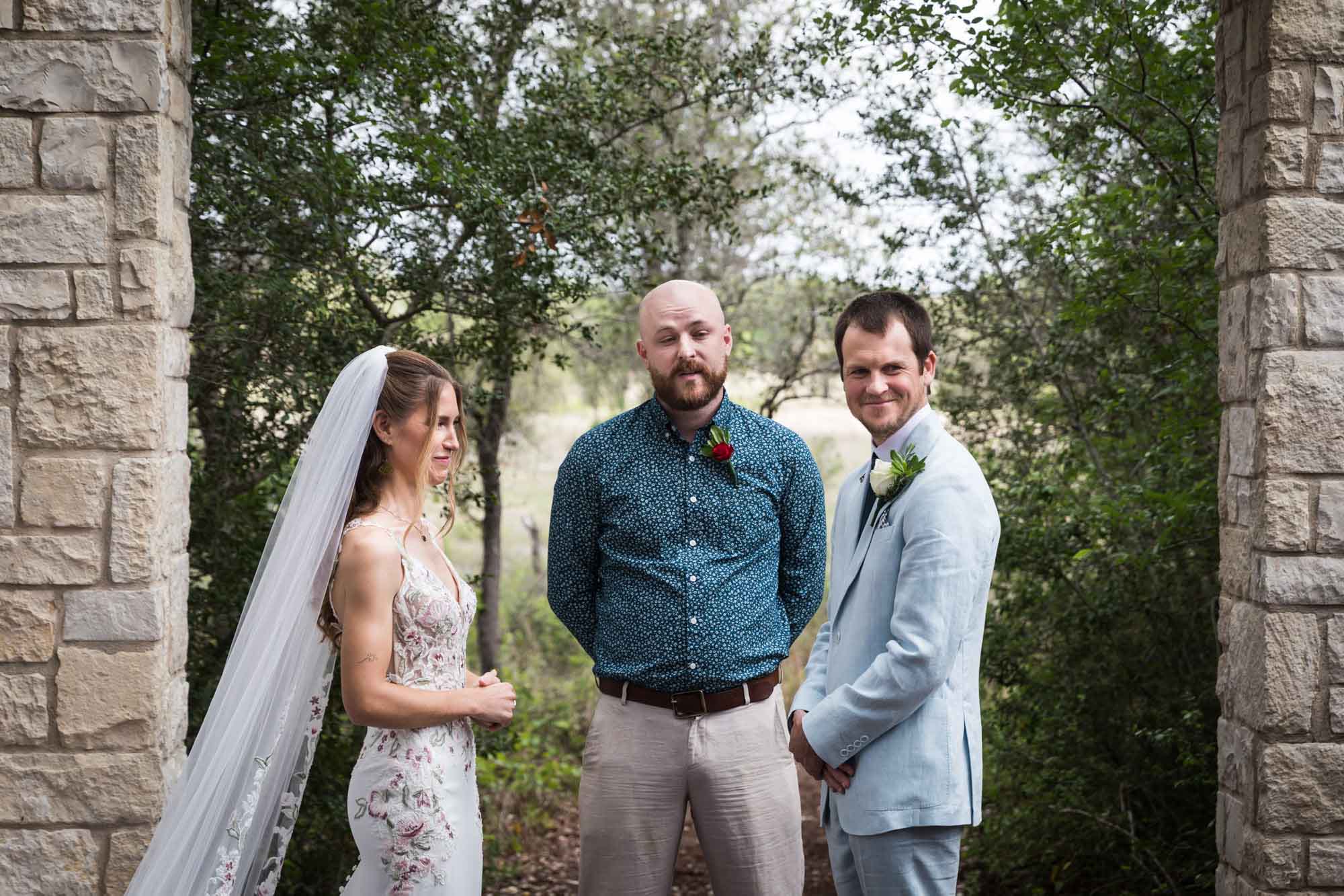 Officiant standing in front of bride and groom at Cecille's Arch during a Lady Bird Johnson Wildflower Center wedding