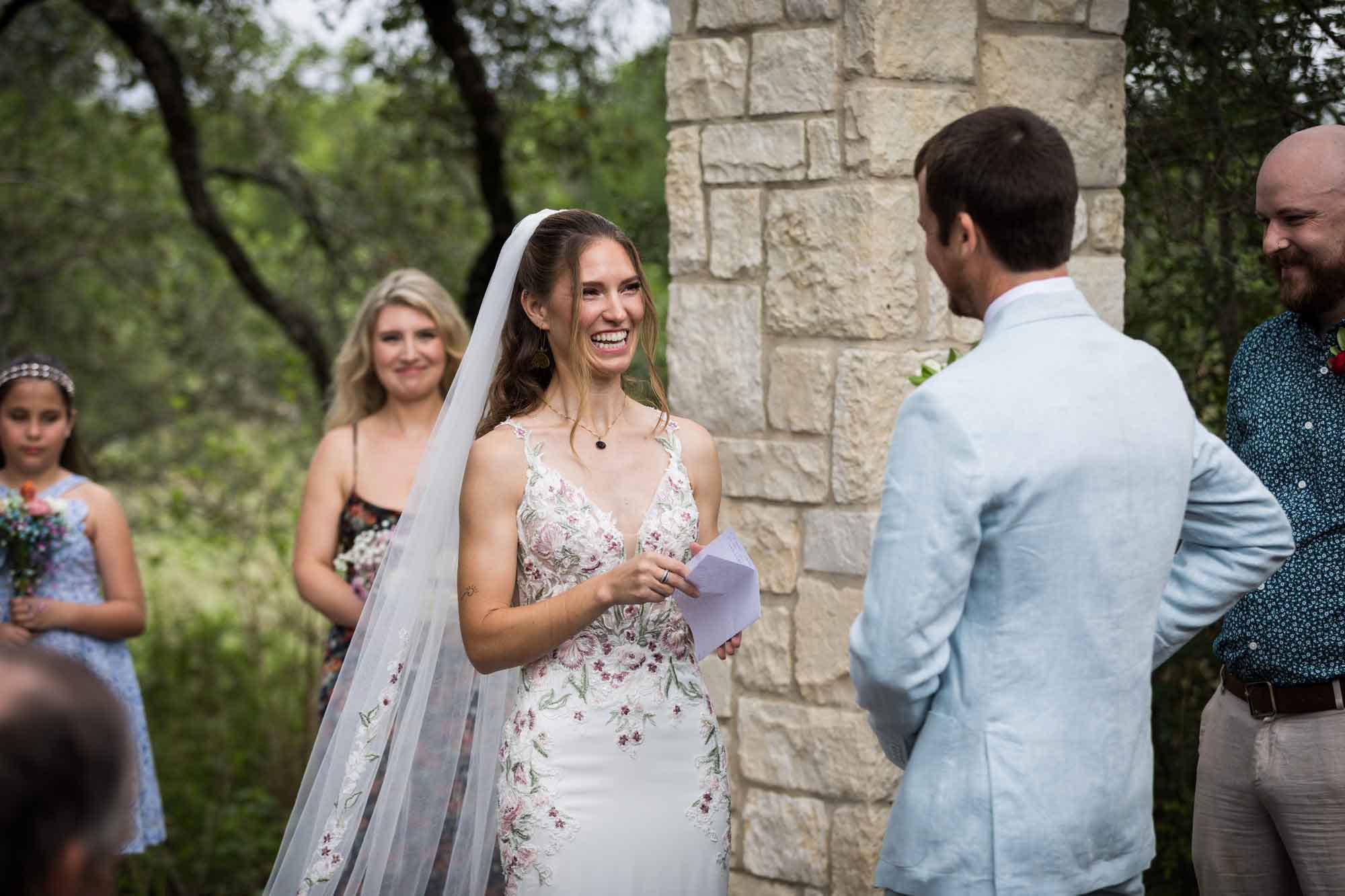 Bride reading vows to groom in front of Cecille's Arch during a Lady Bird Johnson Wildflower Center wedding