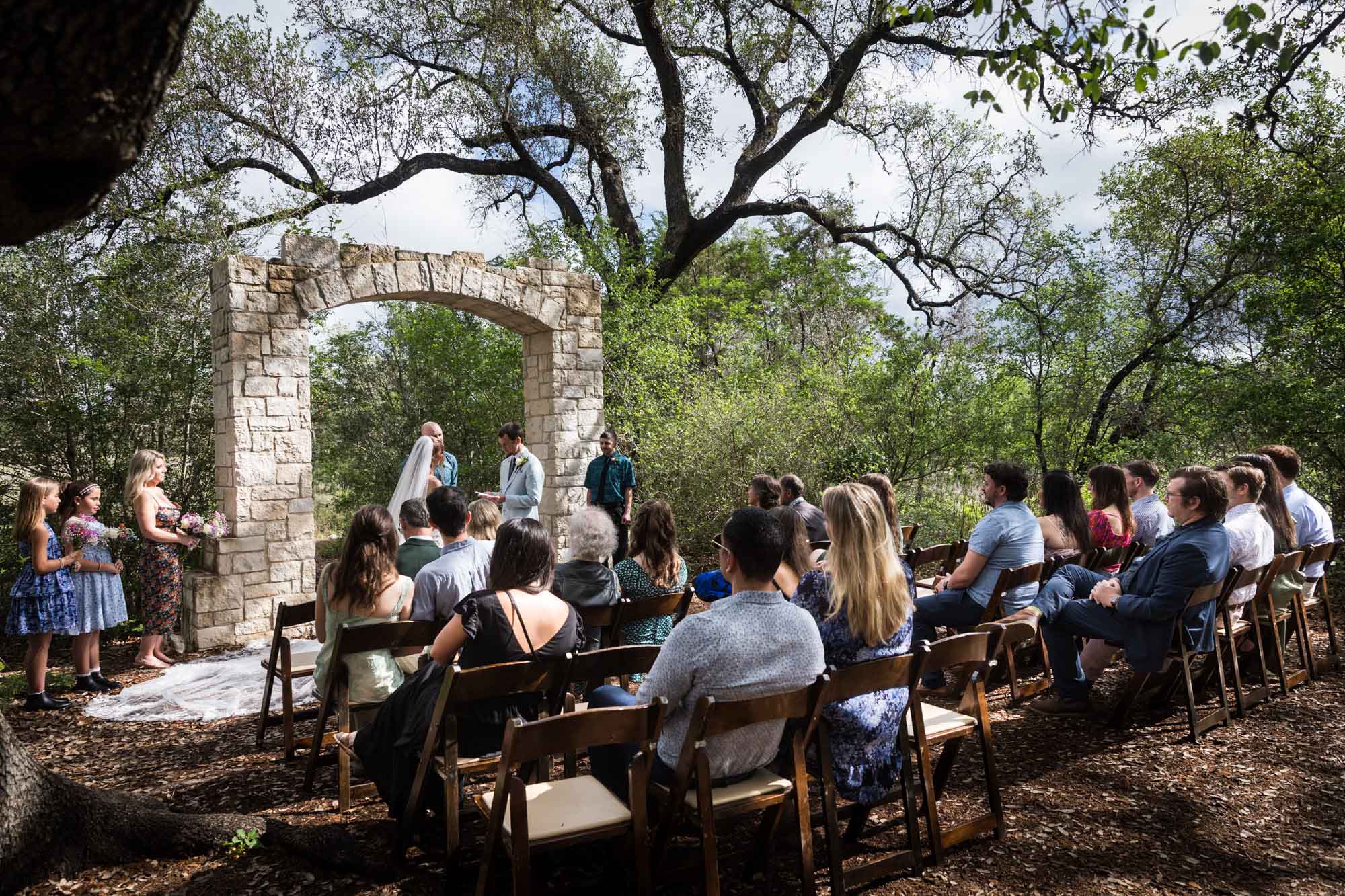 Wide shot of guests watching ceremony at Cecille's Arch during a Lady Bird Johnson Wildflower Center wedding