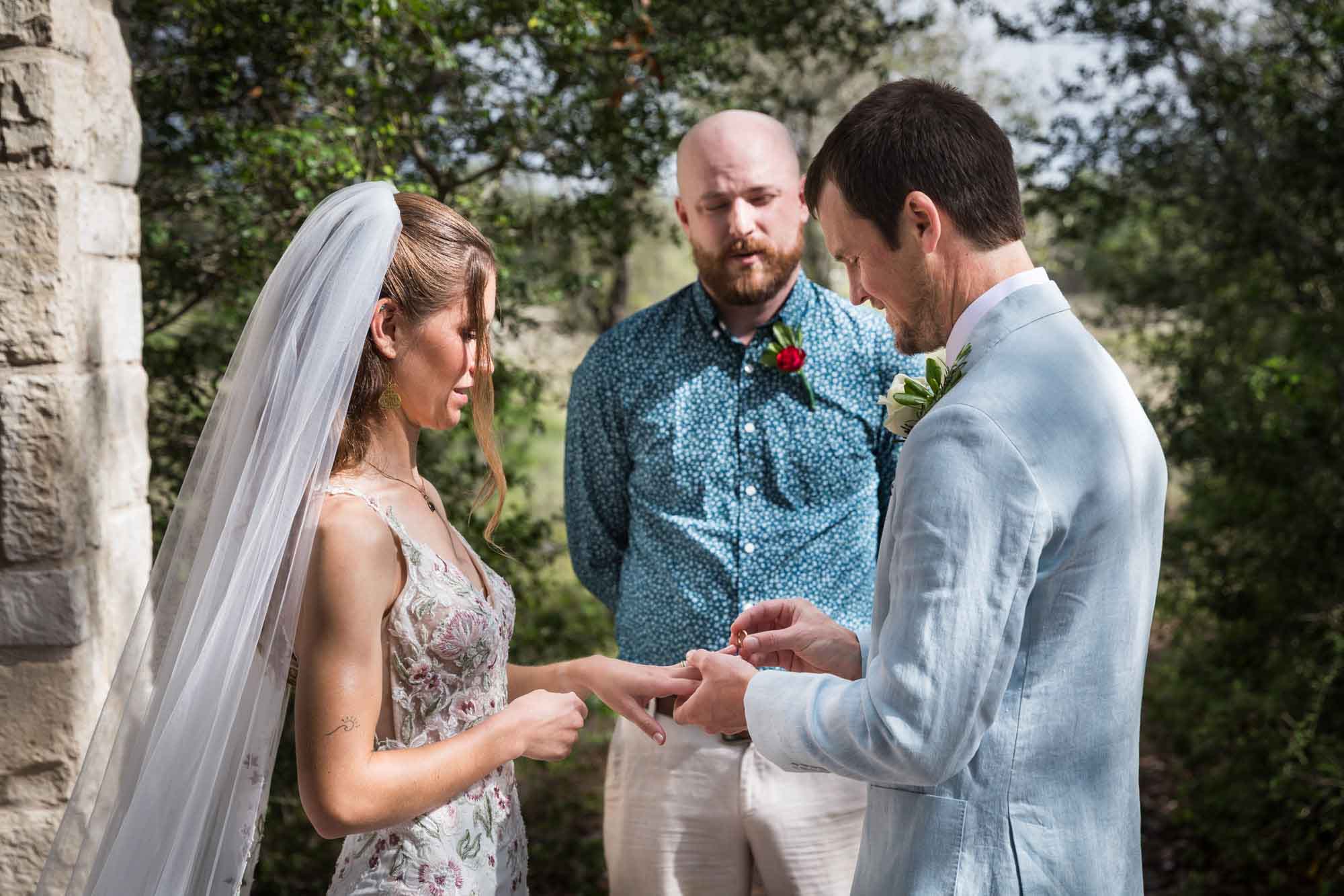 Bride watching groom read vows at Cecille's Arch during a Lady Bird Johnson Wildflower Center wedding