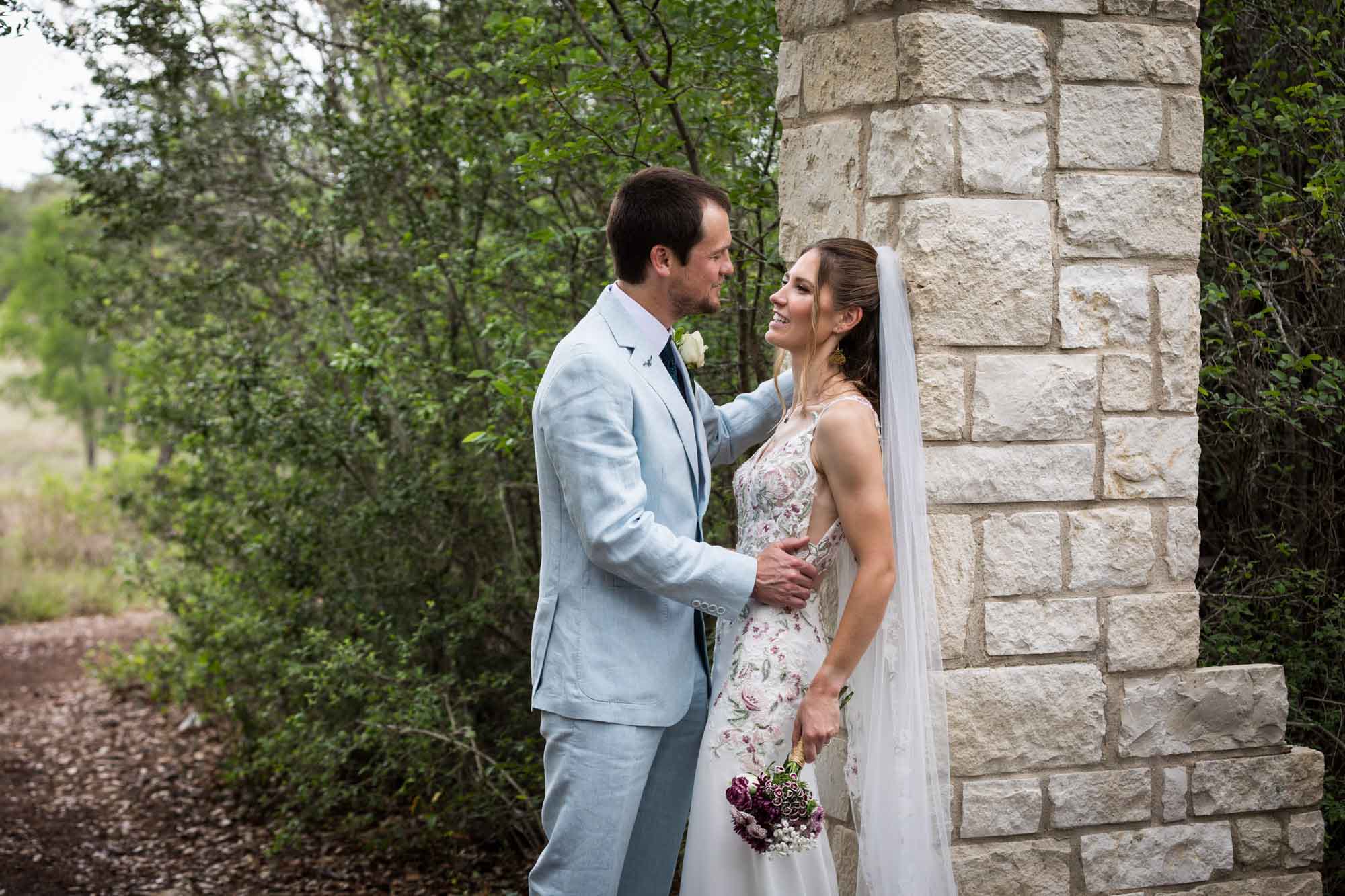Lady Bird Johnson Wildflower Center wedding photos of bride and groom leaning against Cecille's Arch