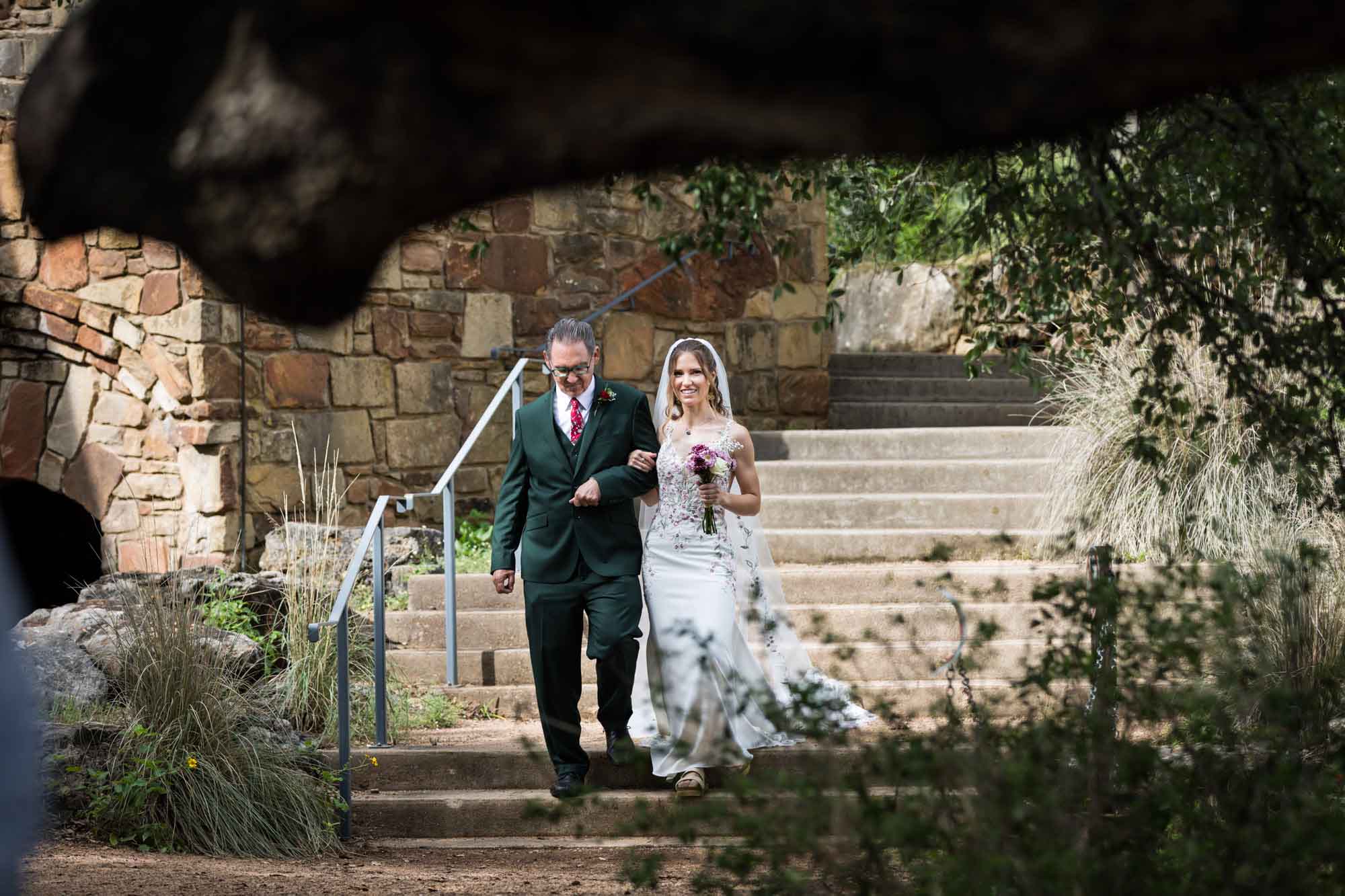 Bride and father walking down steps during ceremony during a Lady Bird Johnson Wildflower Center wedding
