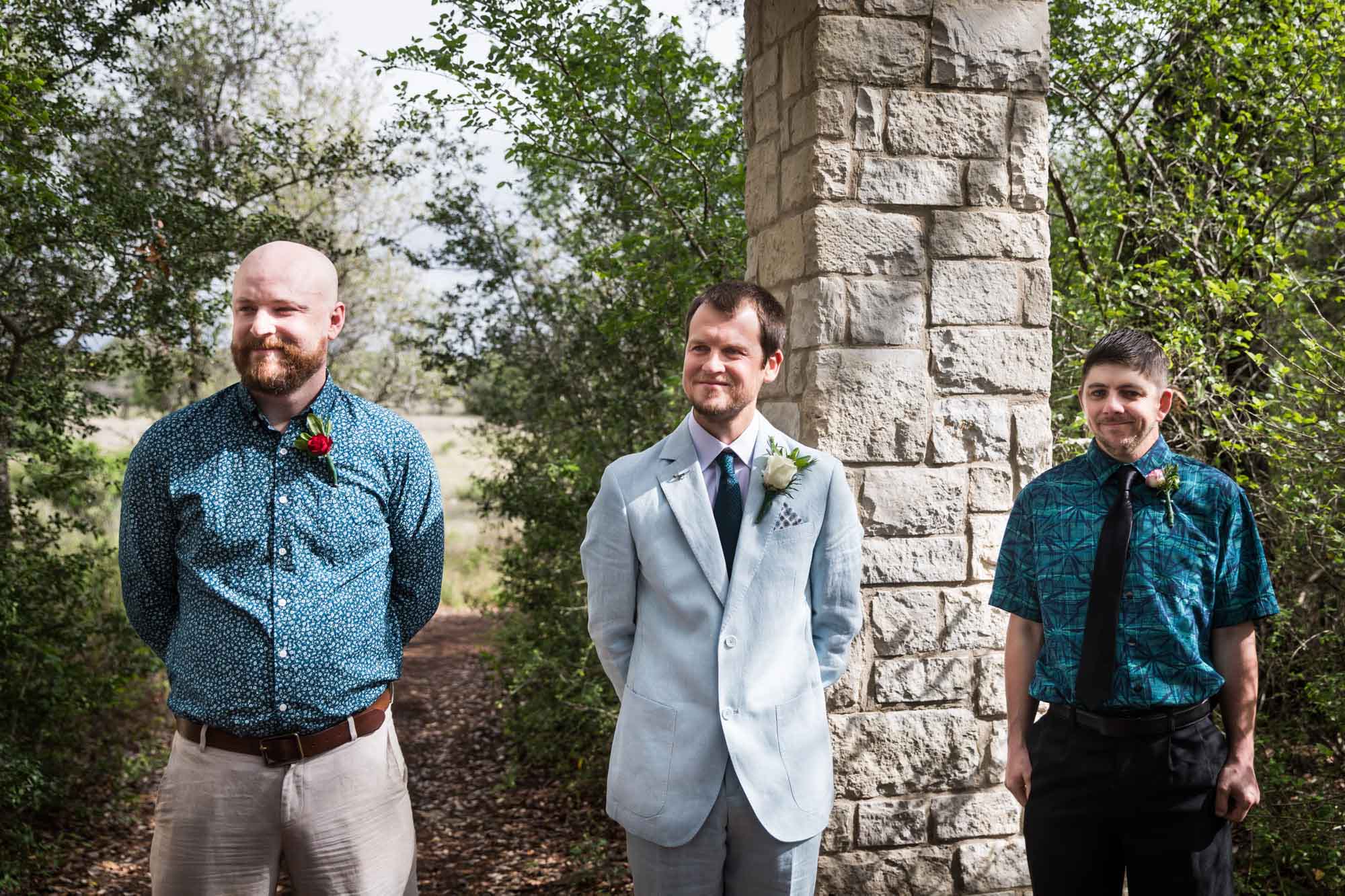 Groom standing with officiant and best man in front of Cecille's Arch during a Lady Bird Johnson Wildflower Center wedding