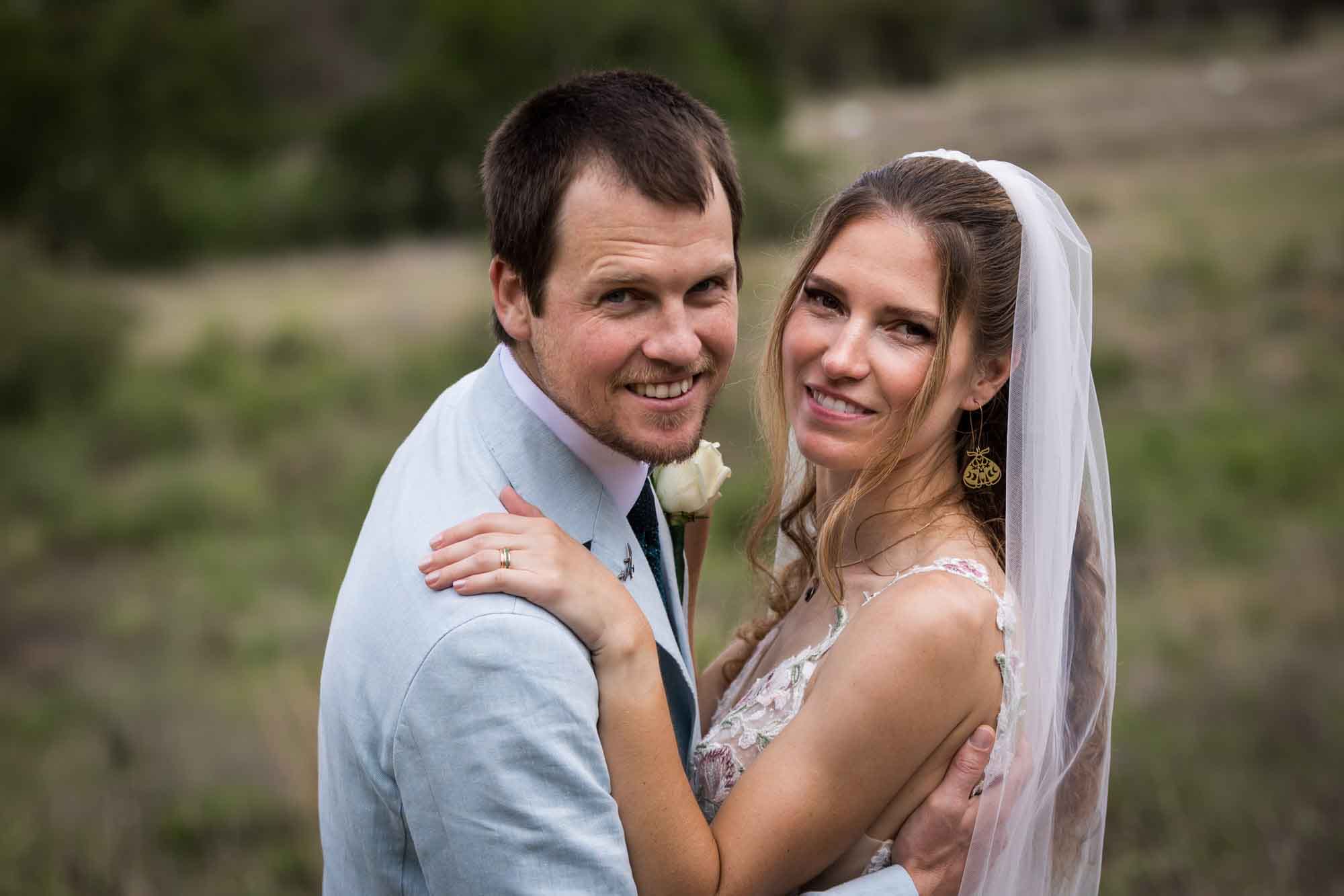 Lady Bird Johnson Wildflower Center wedding photos of a bride and groom hugging in middle of Savanna Meadow