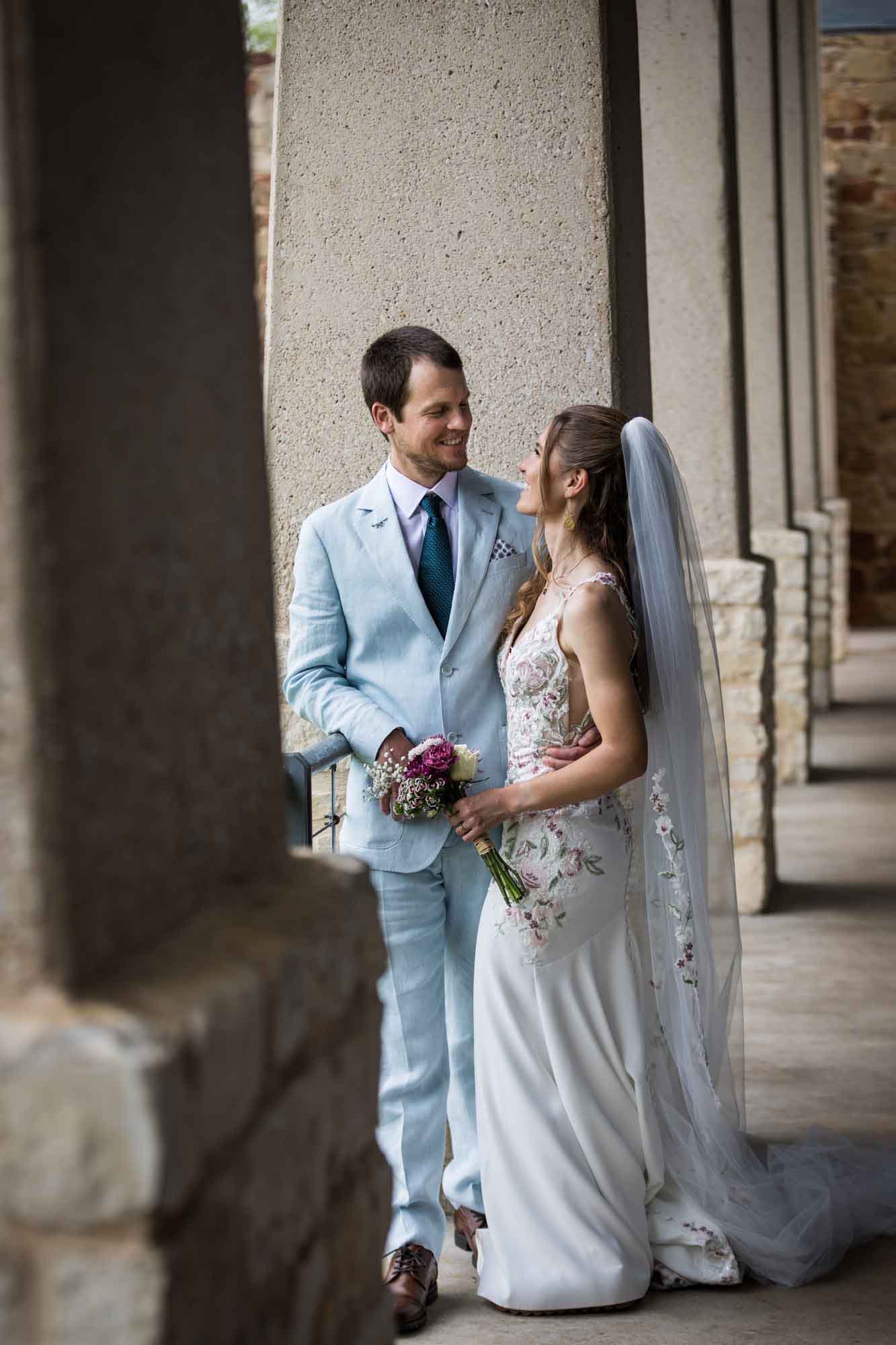 Lady Bird Johnson Wildflower Center wedding photos of a bride and groom standing in between limestone columns