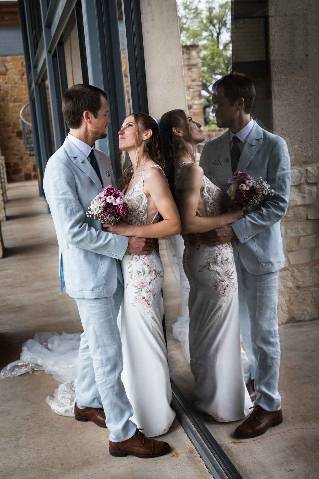 Lady Bird Johnson Wildflower Center wedding photos of a bride and groom standing in front of reflective glass windows