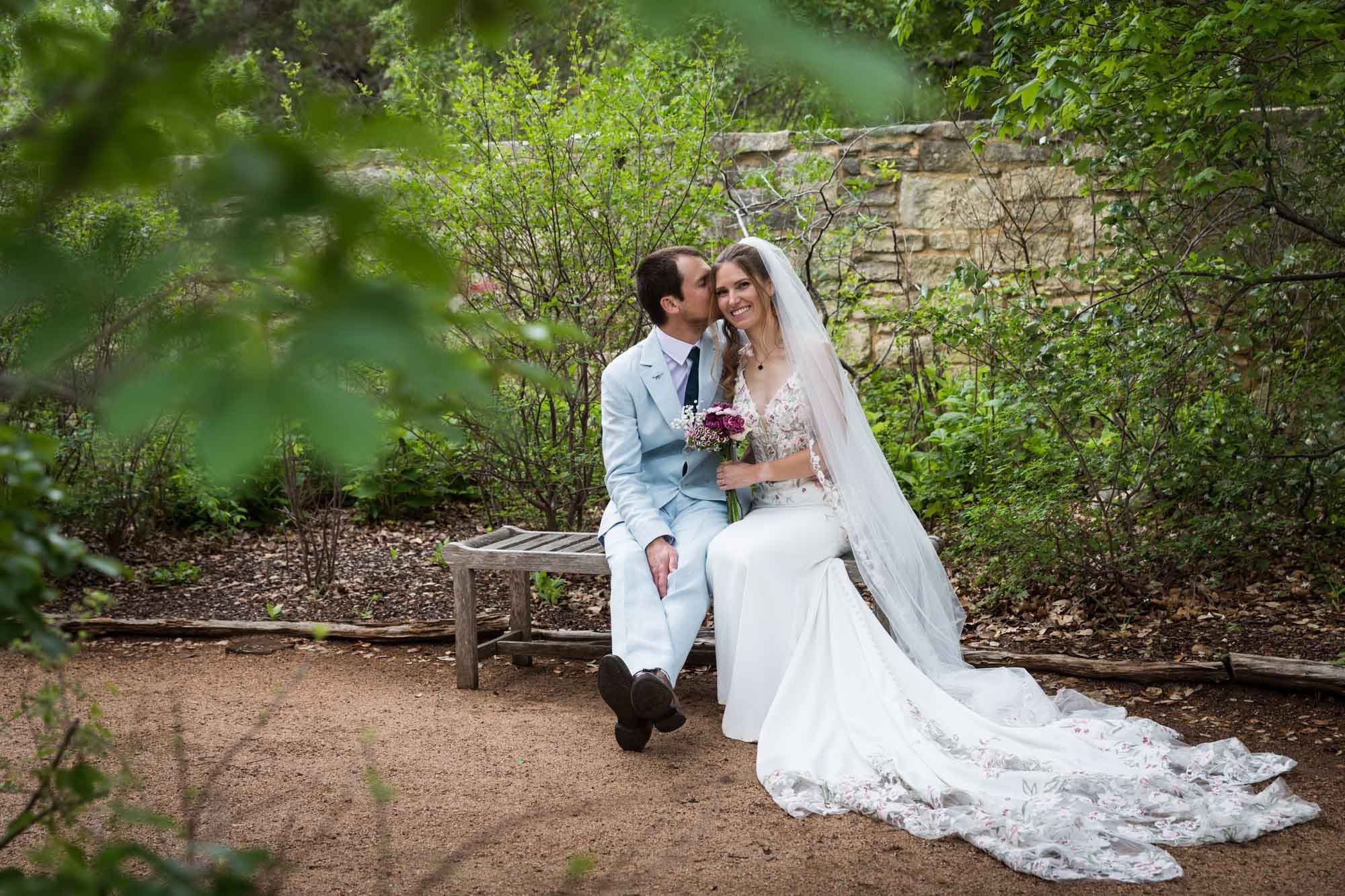 Lady Bird Johnson Wildflower Center wedding photos of a bride and groom sitting on bench