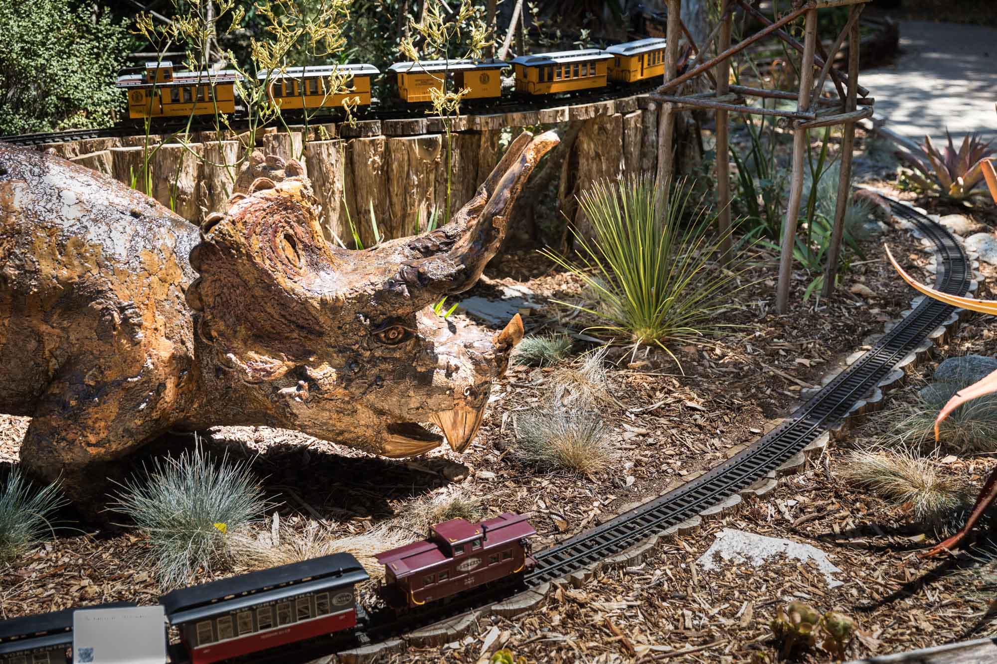 Dinosaur sculpture in front of miniature train display for an article on the best photo shoot locations in Descanso Gardens