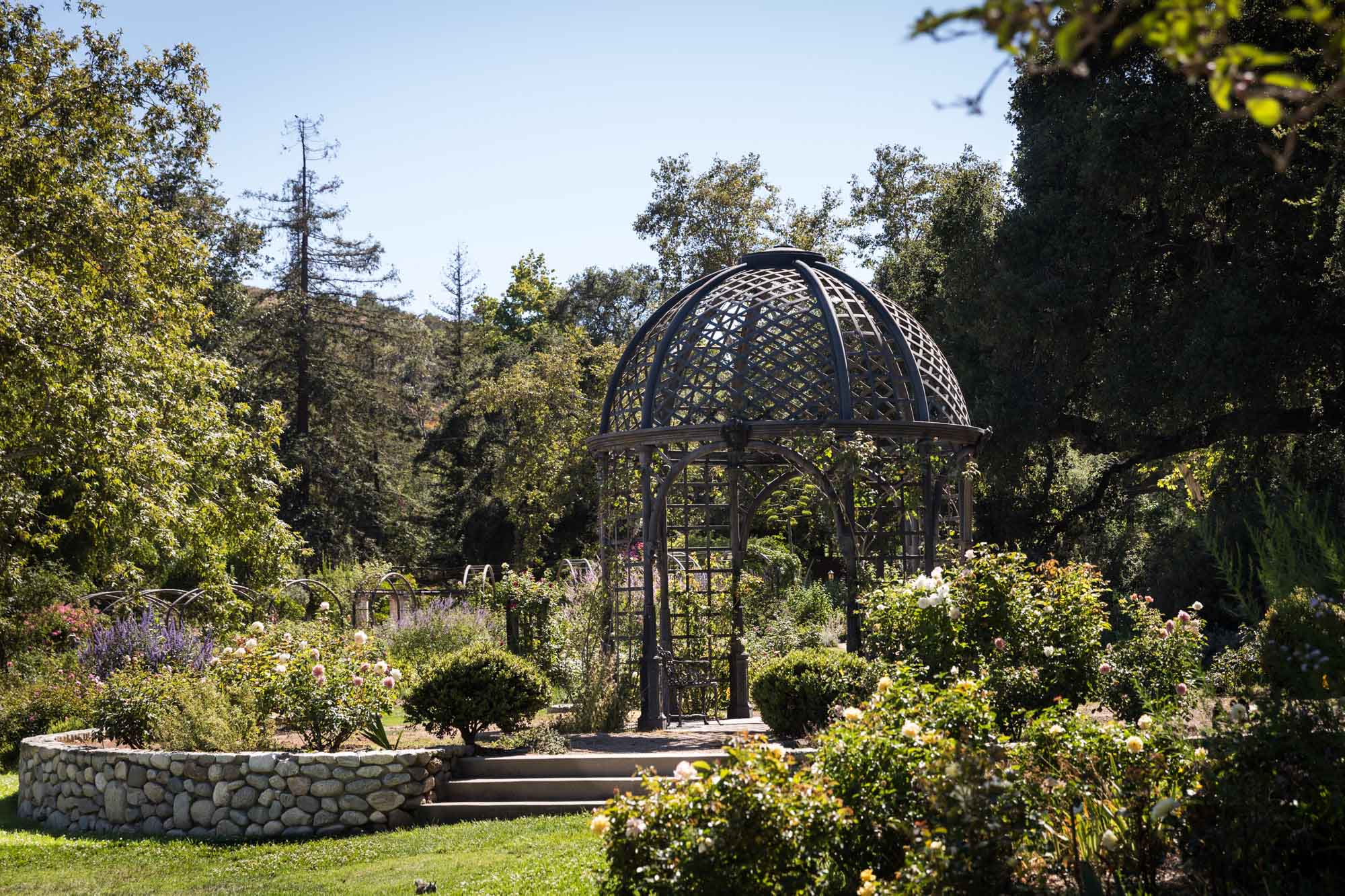 Iron gazebo in Rose Garden surrounded by colorful flowers for an article on the best photo shoot locations in Descanso Gardens