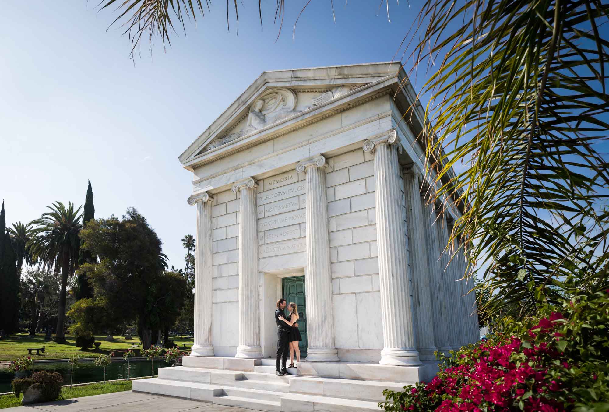 Hollywood Forever Cemetery engagement portrait of man and woman hugging on steps of the Clark Mausoleum