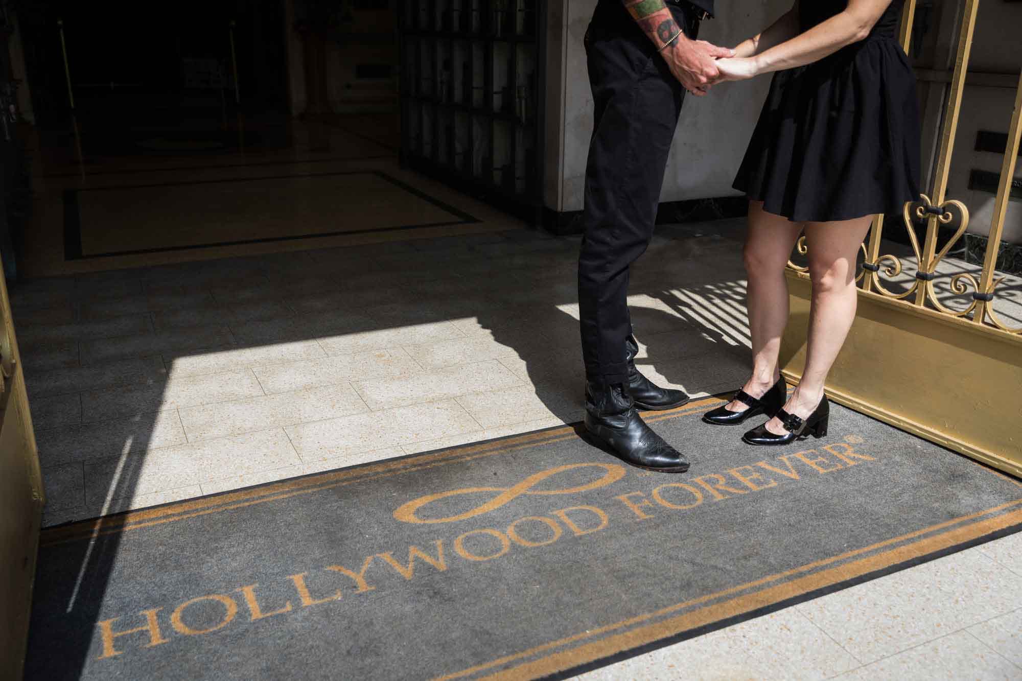 Hollywood Forever place mat and close up on feet and legs of man and woman during a Hollywood Forever Cemetery engagement portrait session