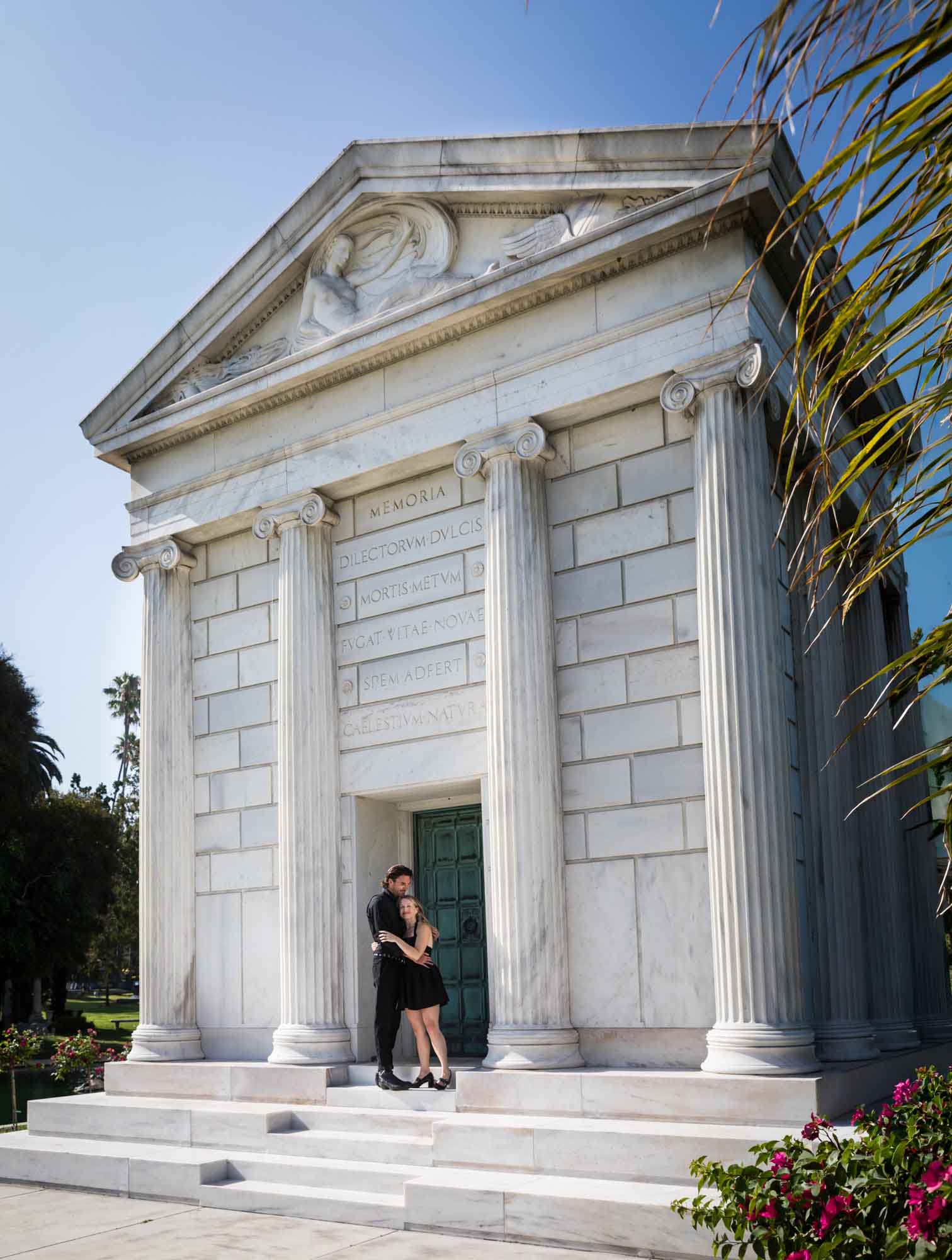 Hollywood Forever Cemetery engagement portrait of man and woman hugging on steps of the Clark Mausoleum