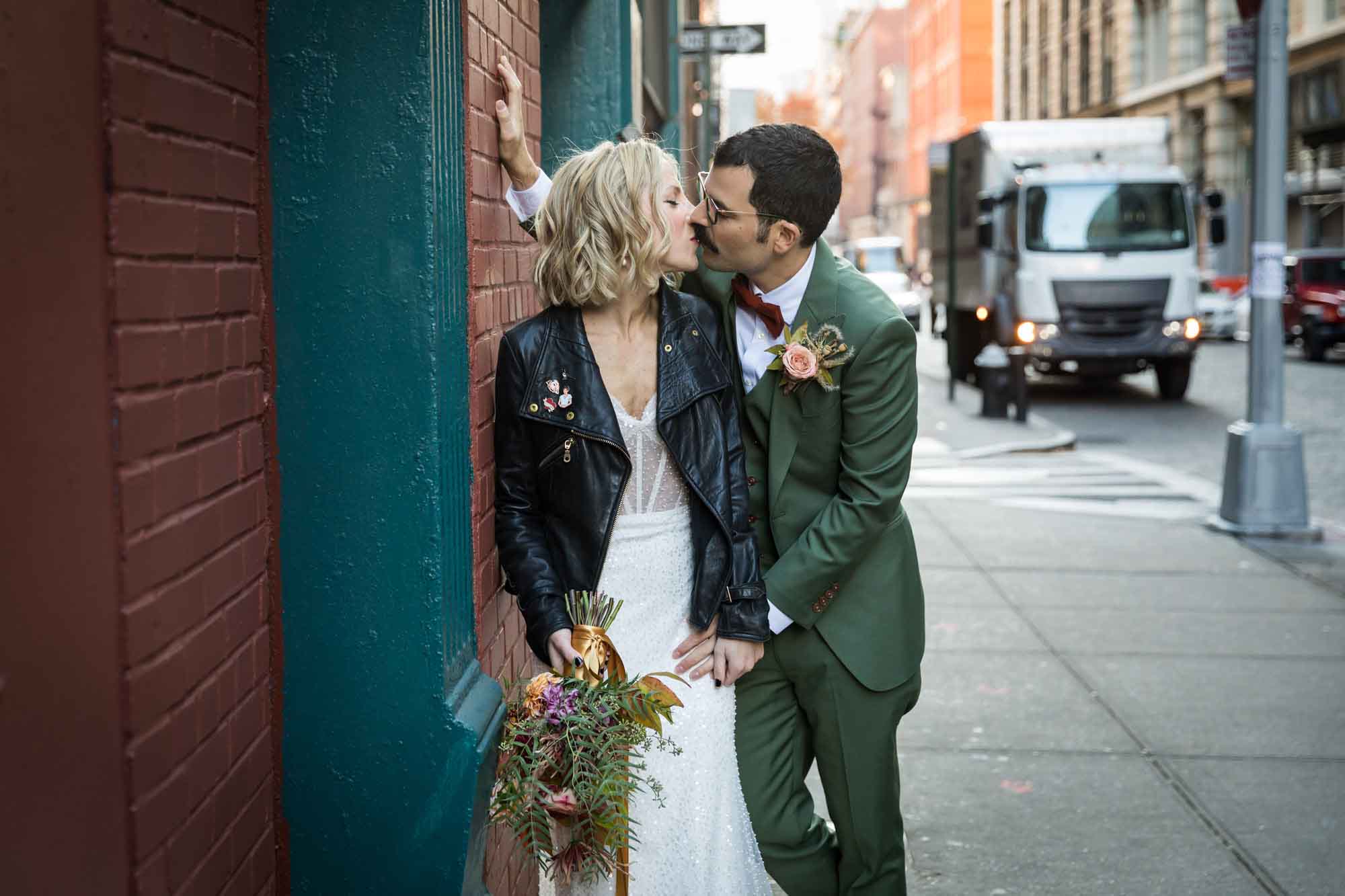 Bride and groom kissing on sidewalk in city for an article on how to get a marriage license in Los Angeles