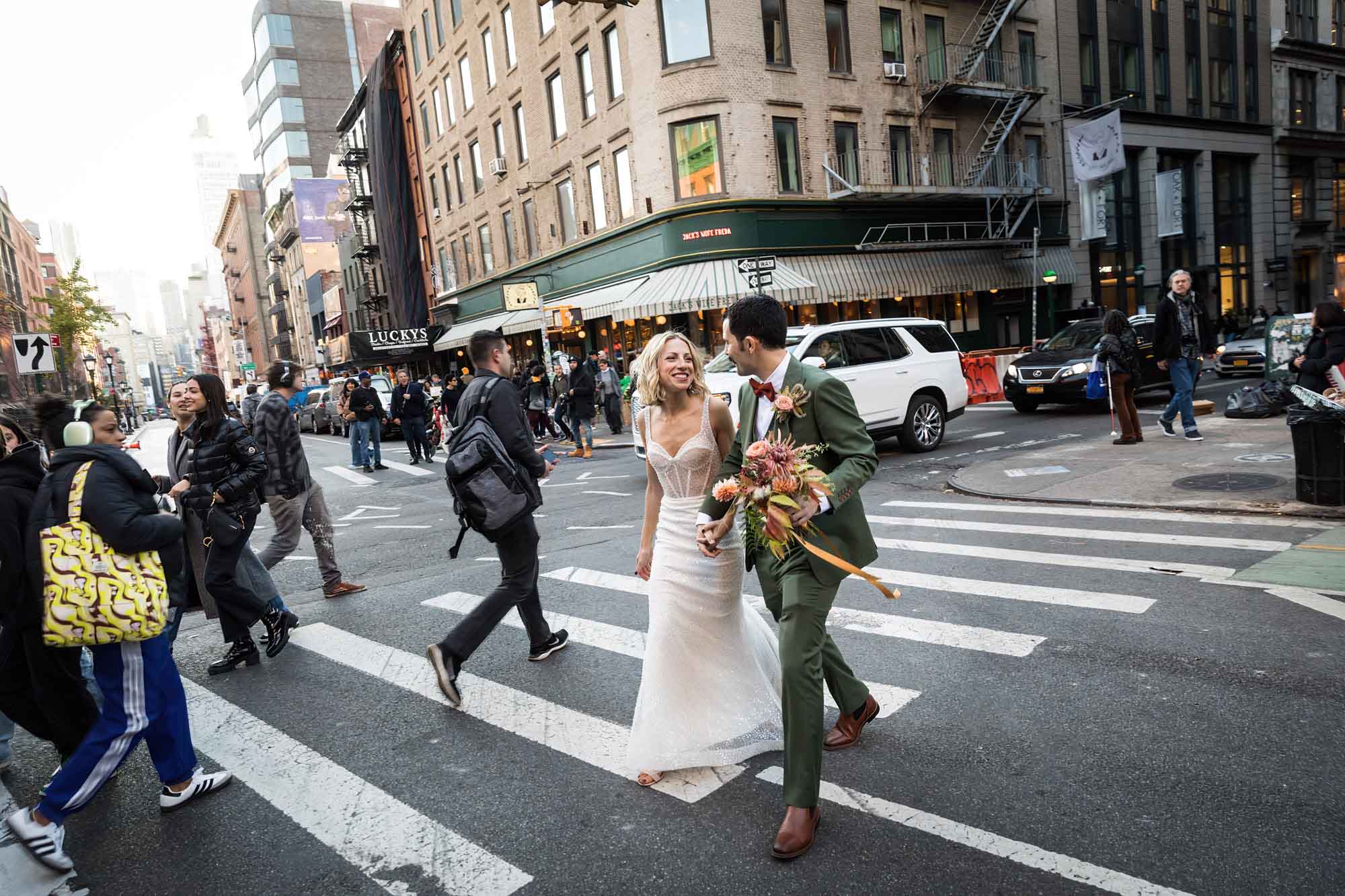 Bride and groom walking in crosswalk with traffic all around for an article on how to get a marriage license in Los Angeles