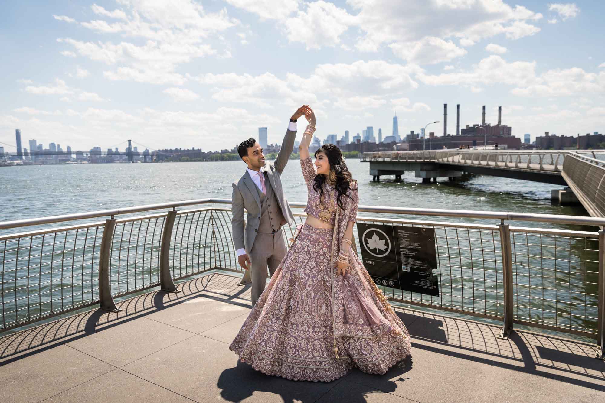 Indian bride dancing with groom on dock in front of water with city skyline in the background for an article on how to get a marriage license in Los Angeles