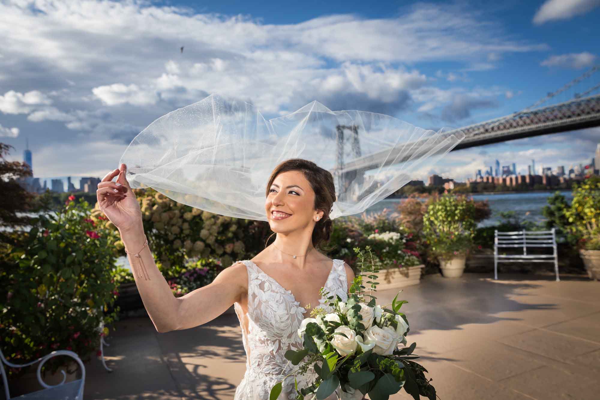 Bride holding on to veil blowing in the wind with clouds overhead for an article on how to get a marriage license in Los Angeles
