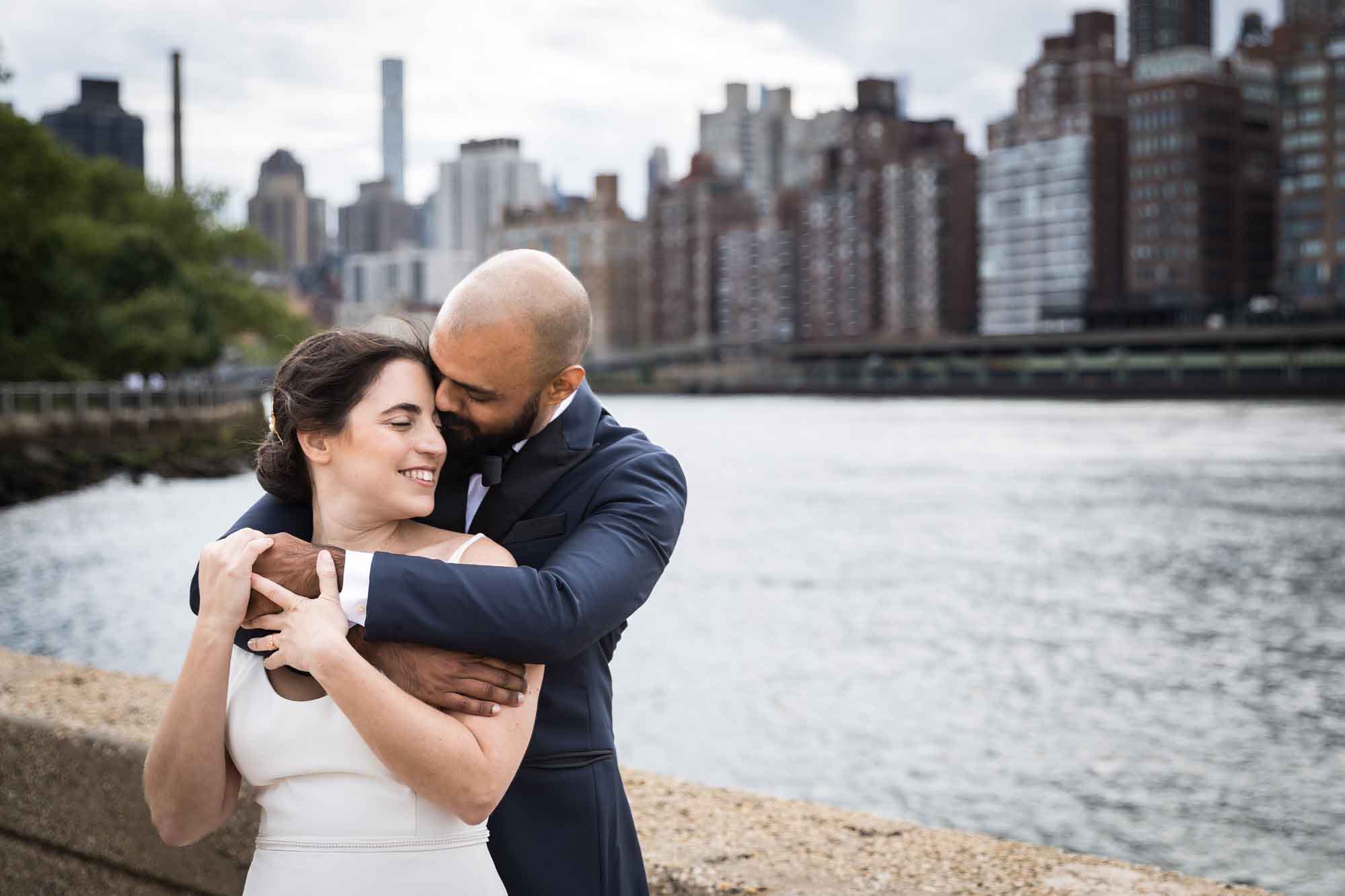 Groom kissing bride from behind with city skyline and waterfront in the background for an article on how to get a marriage license in Los Angeles