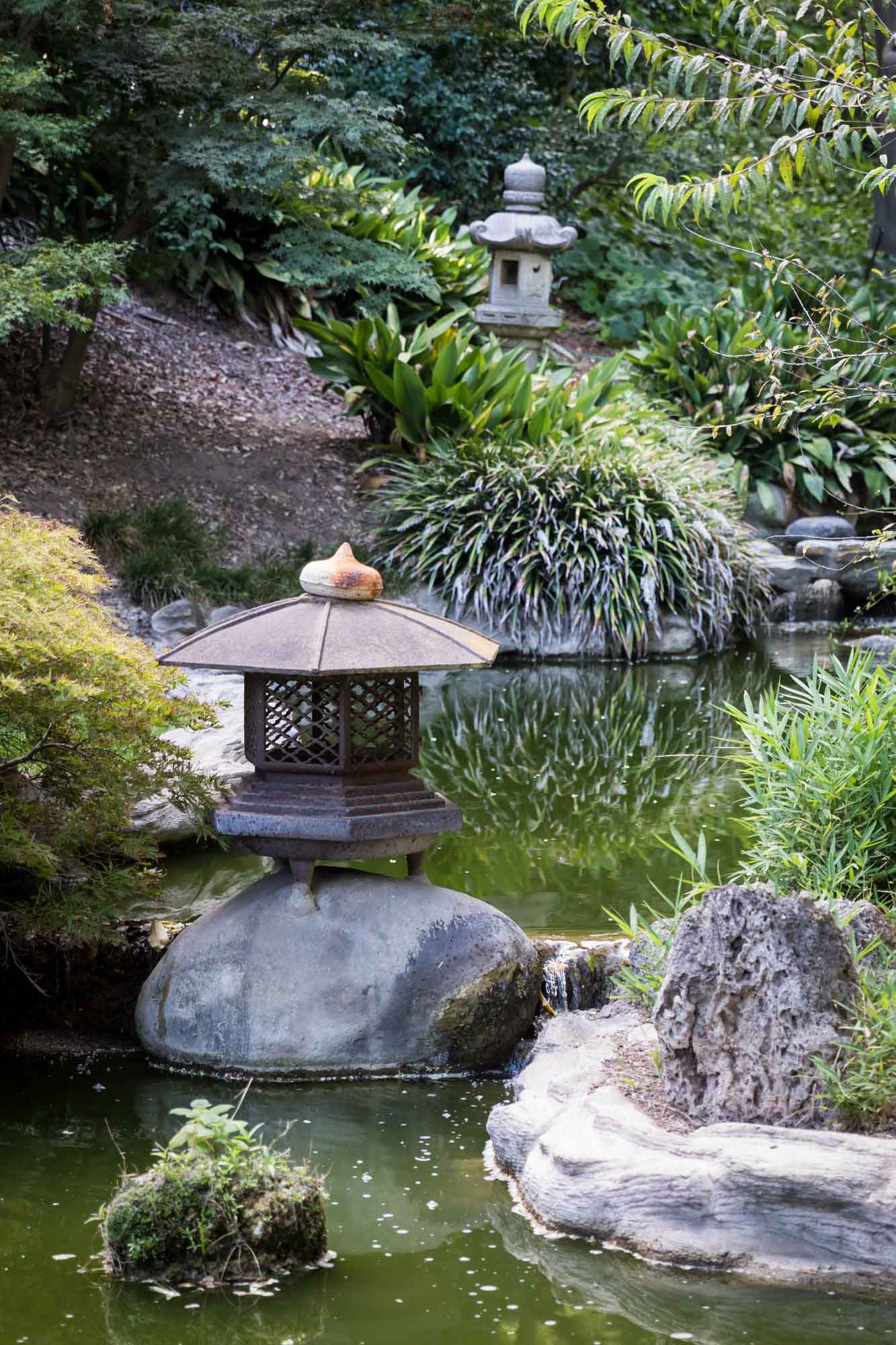 Two stone lanterns along a creek in Japanese Garden for a Huntington Gardens photo shoot guide article