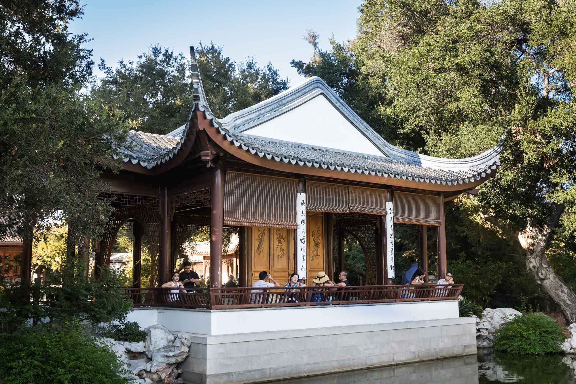 Asian-style building with pitched roof on side of pond in Chinese Garden for a Huntington Gardens photo shoot guide article
