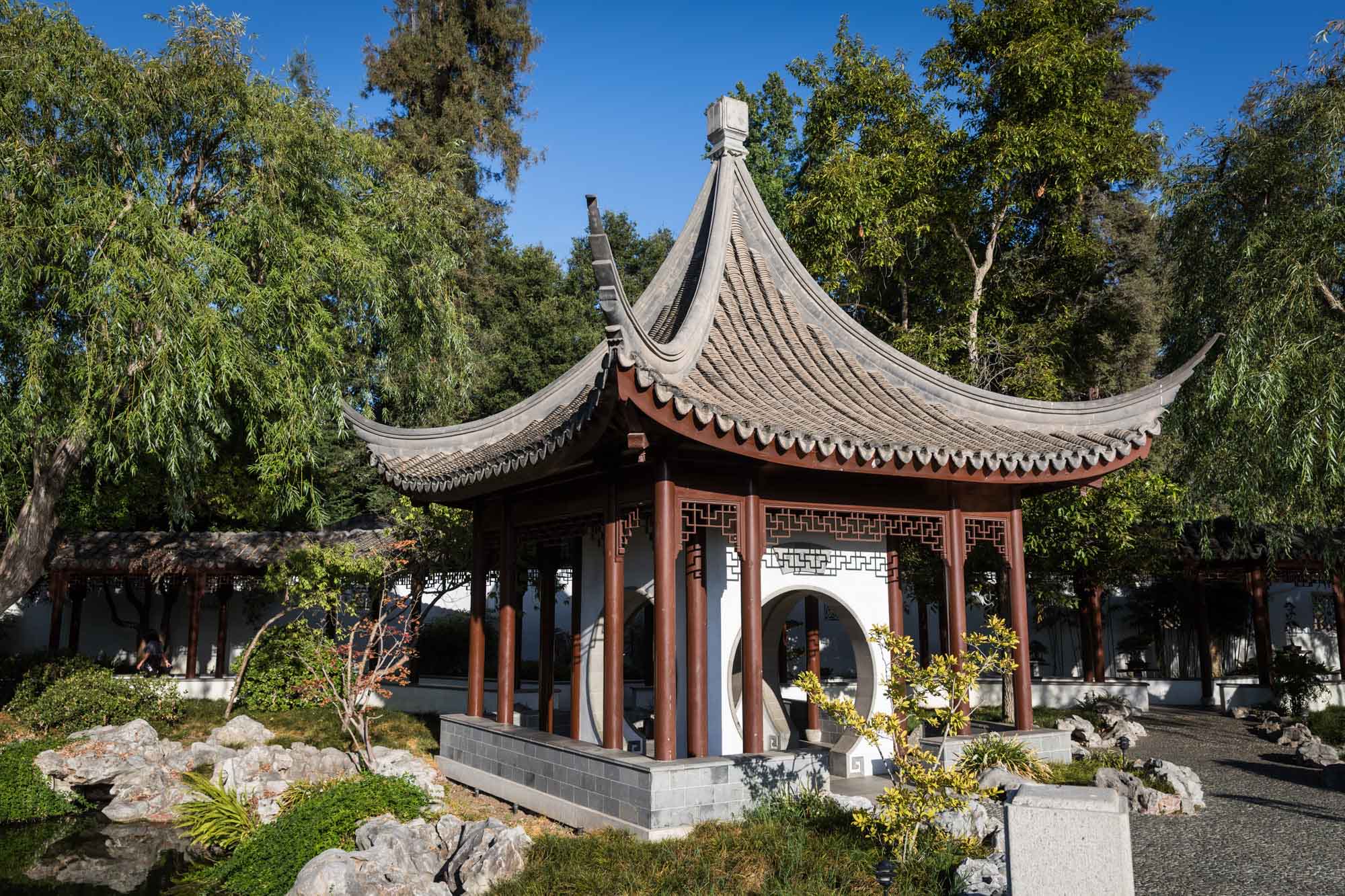 Asian-style building with pitched roof on side of pond in Chinese Garden for a Huntington Gardens photo shoot guide article