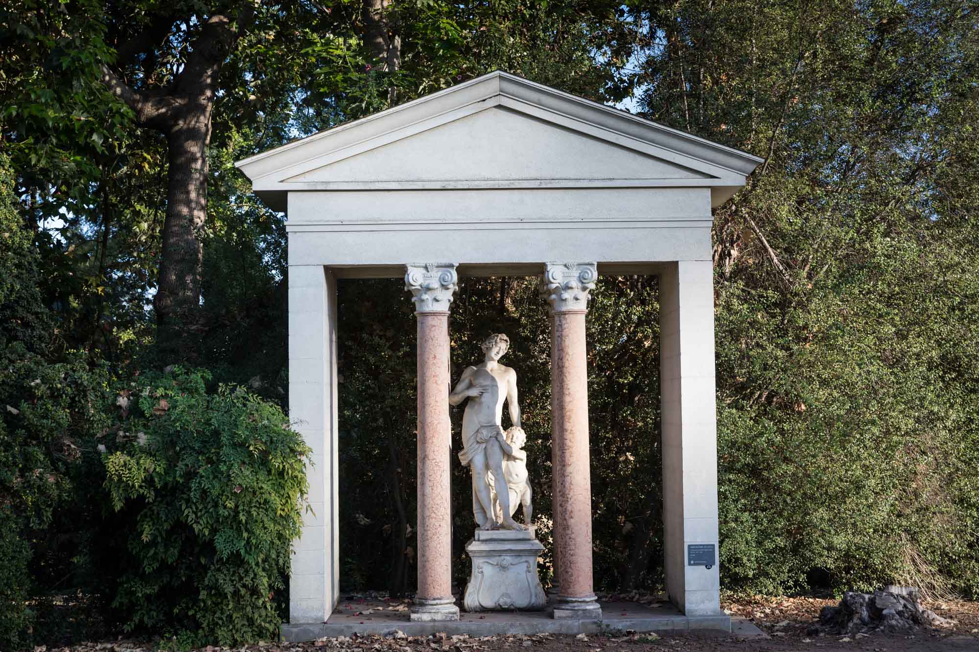 Architectural stone sculpture with two columns and stone figure on a lawn for a Huntington Gardens photo shoot guide article