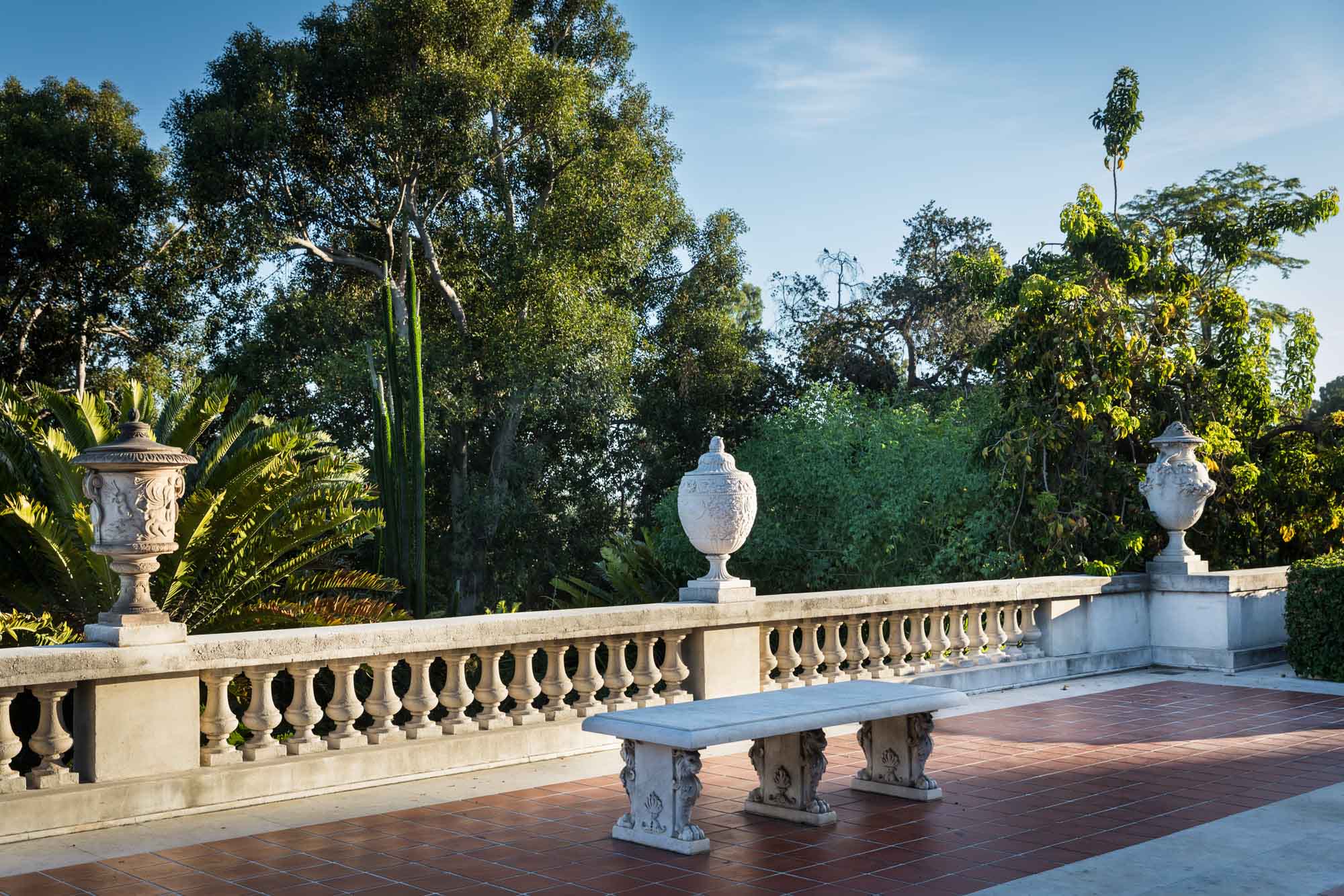 Ornate stone terrace with stone urns and benches at the Huntington Art Gallery building for a Huntington Gardens photo shoot guide article