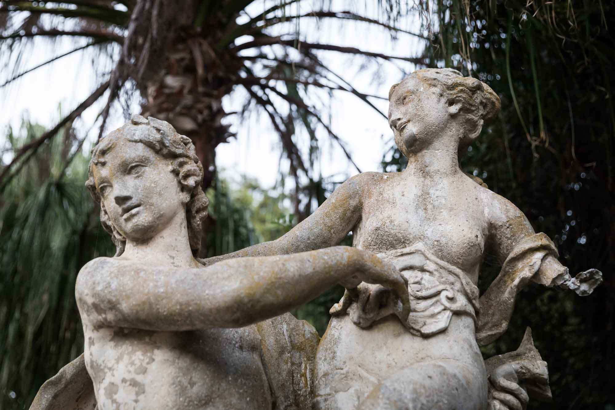 Stone sculpture of two classical figures embracing in a garden for a Huntington Gardens photo shoot guide article