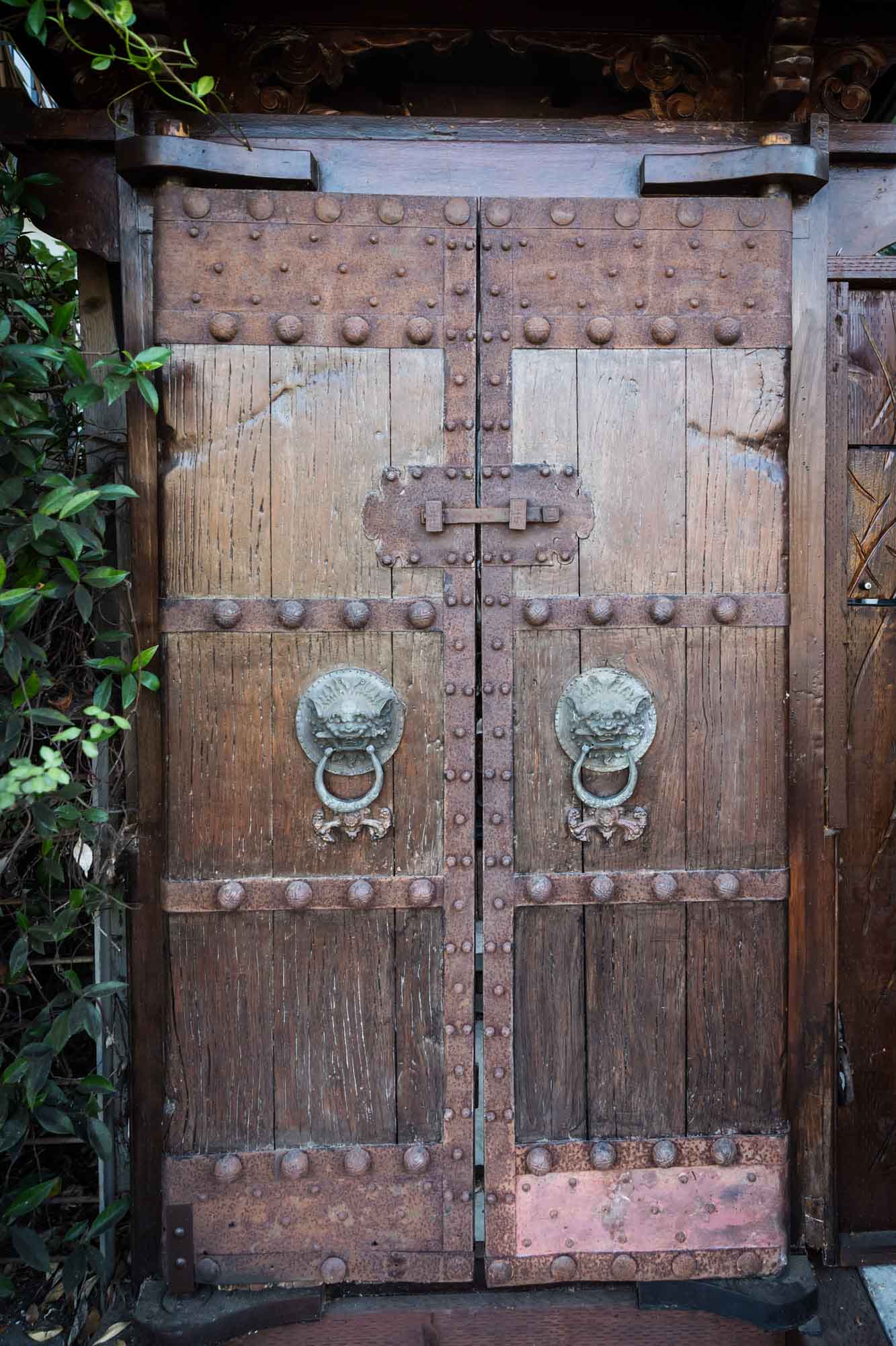 Intricate, Asian-style wooden doors with large metal knockers in the shape of animals for an article on Venice Canals engagement photos