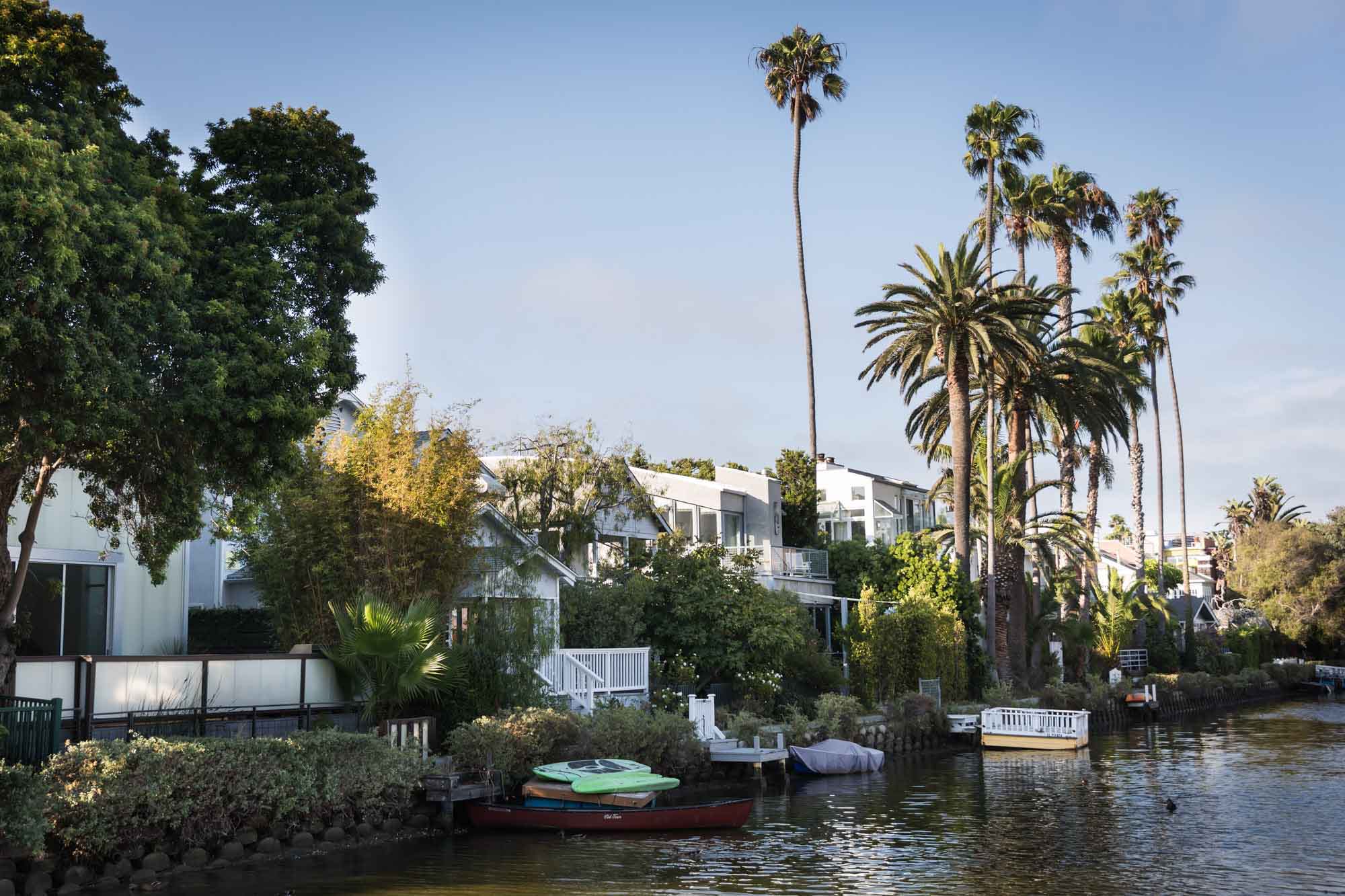Multiple houses lining the Venice Canal with trees and rowboats for an article on Venice Canals engagement photos