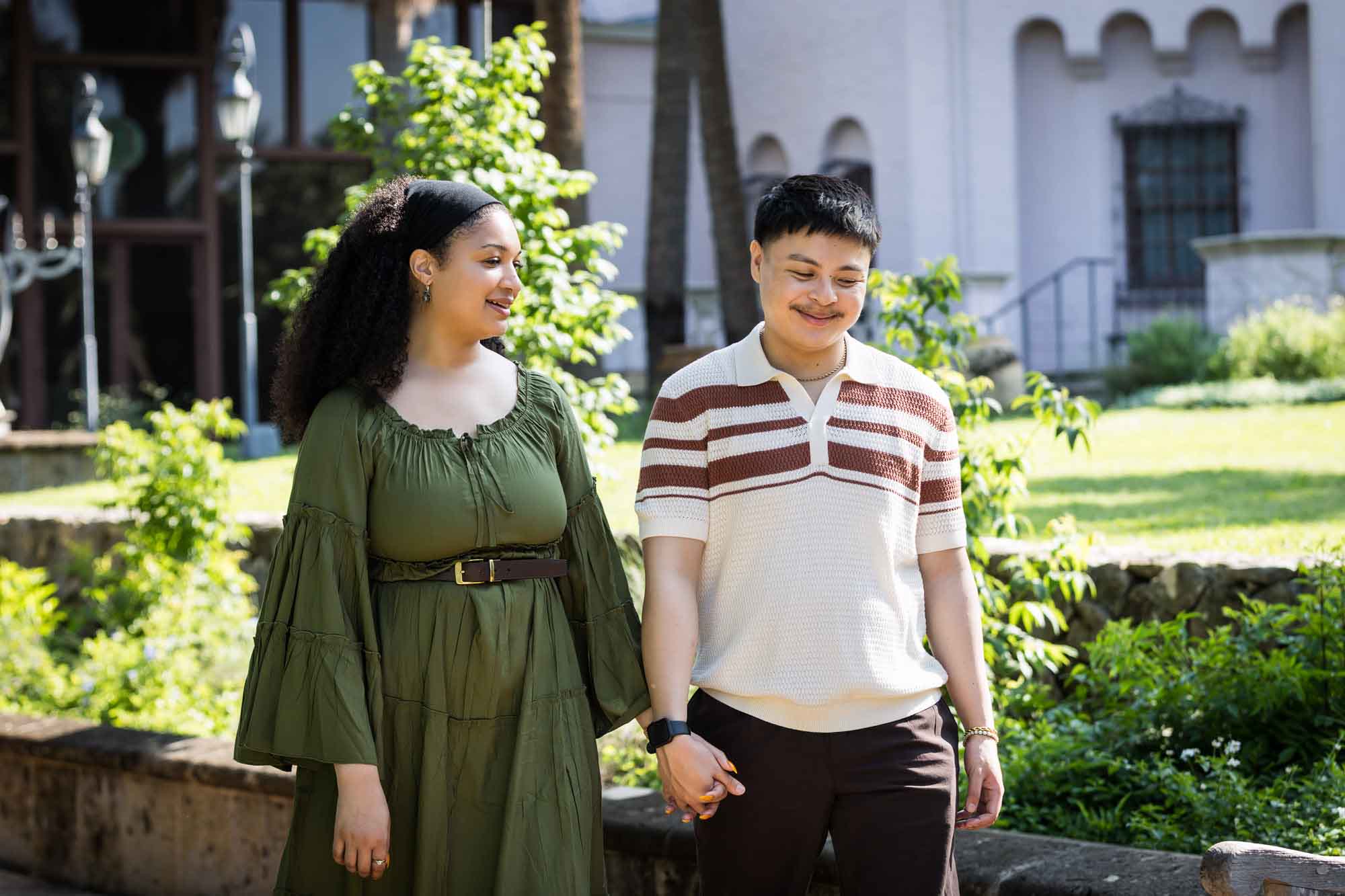 Man and woman walking hand in hand in a garden for an article on Venice Canals engagement photos