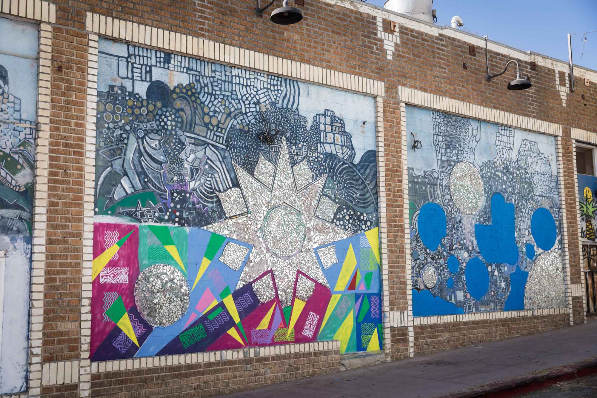 A colorful mural with mirrors on a brick wall in Venice Beach for an article on Venice Canals engagement photos