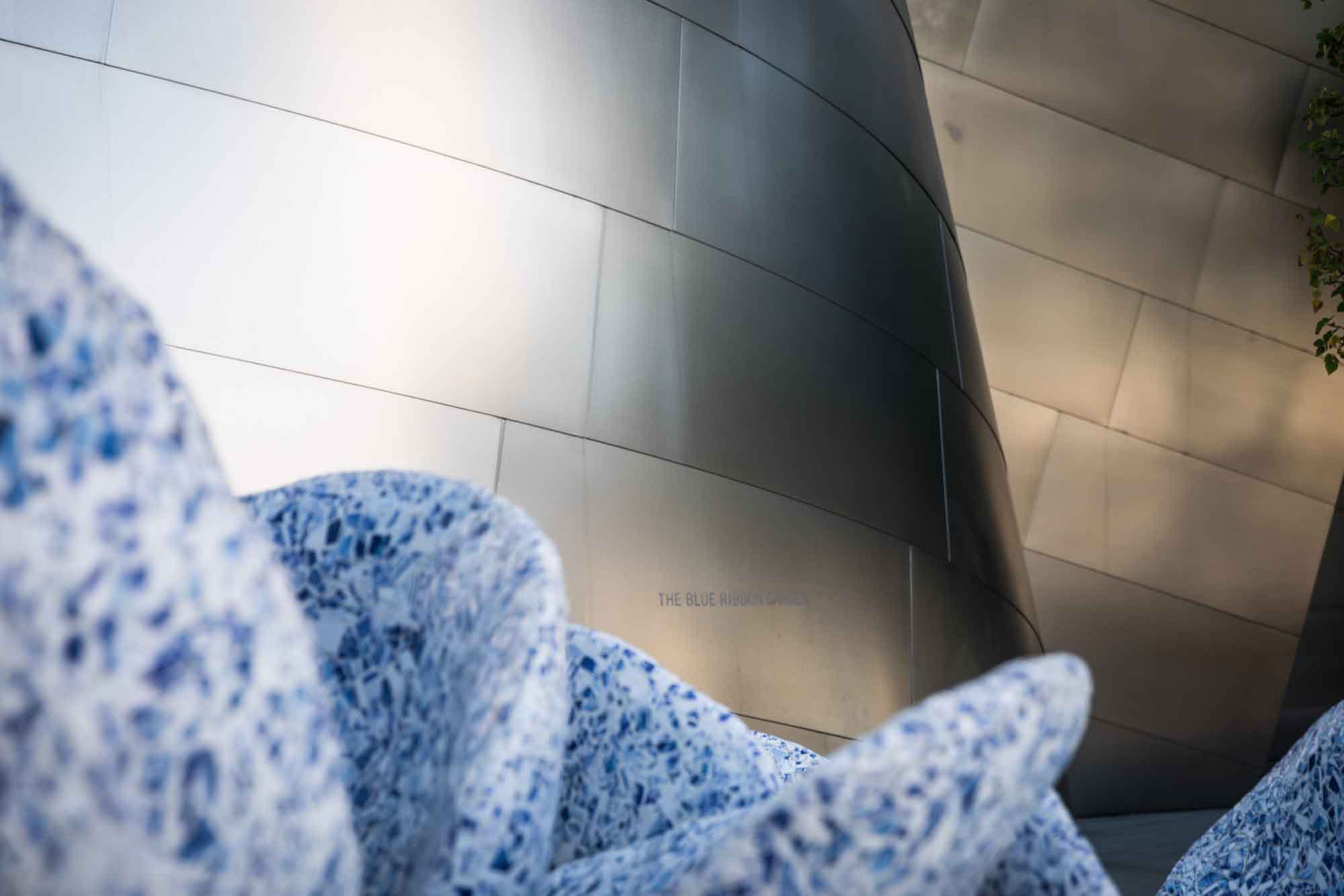 View over blue mosaic-covered fountain to silver-covered walls of Walt Disney Concert Hall for an article on Walt Disney Concert Hall photos