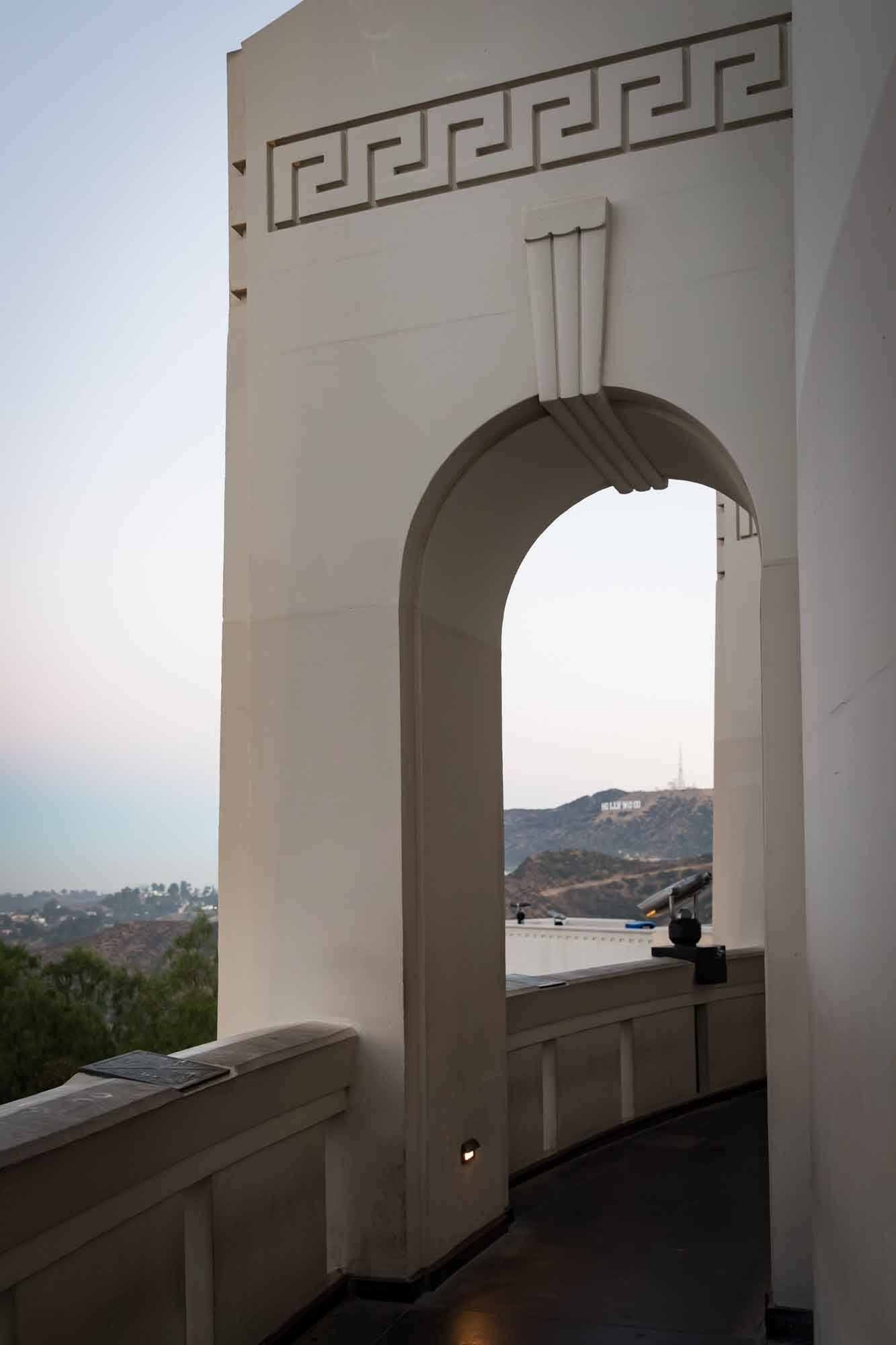 View of Hollywood Sign and binoculars as seen through arches of roof of Griffith Observatory for an article on where to propose at the Griffith Observatory
