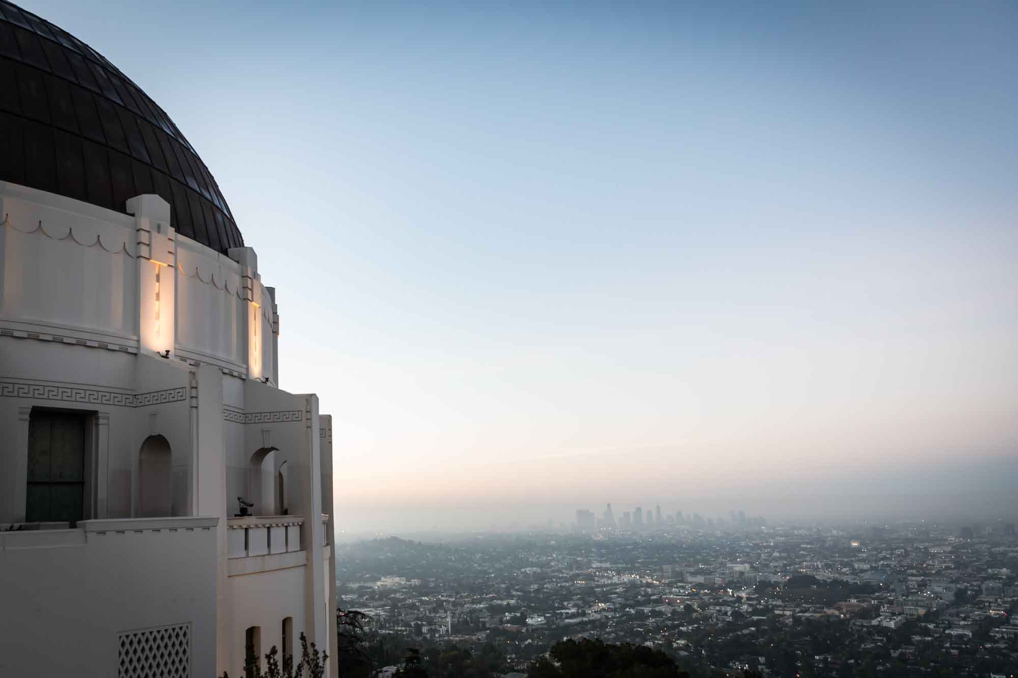 Los Angeles skyline in the background with view of observatory roof at sunrise for an article on where to propose at the Griffith Observatory
