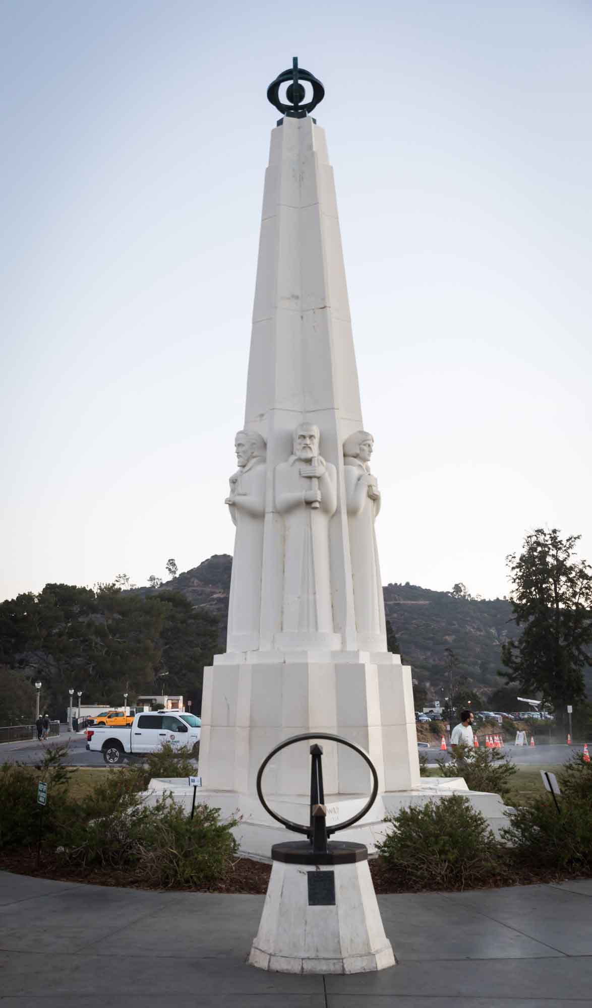 Astronomers Monument sculpture and sundial in front entrance and parking lot in background for an article on where to propose at the Griffith Observatory