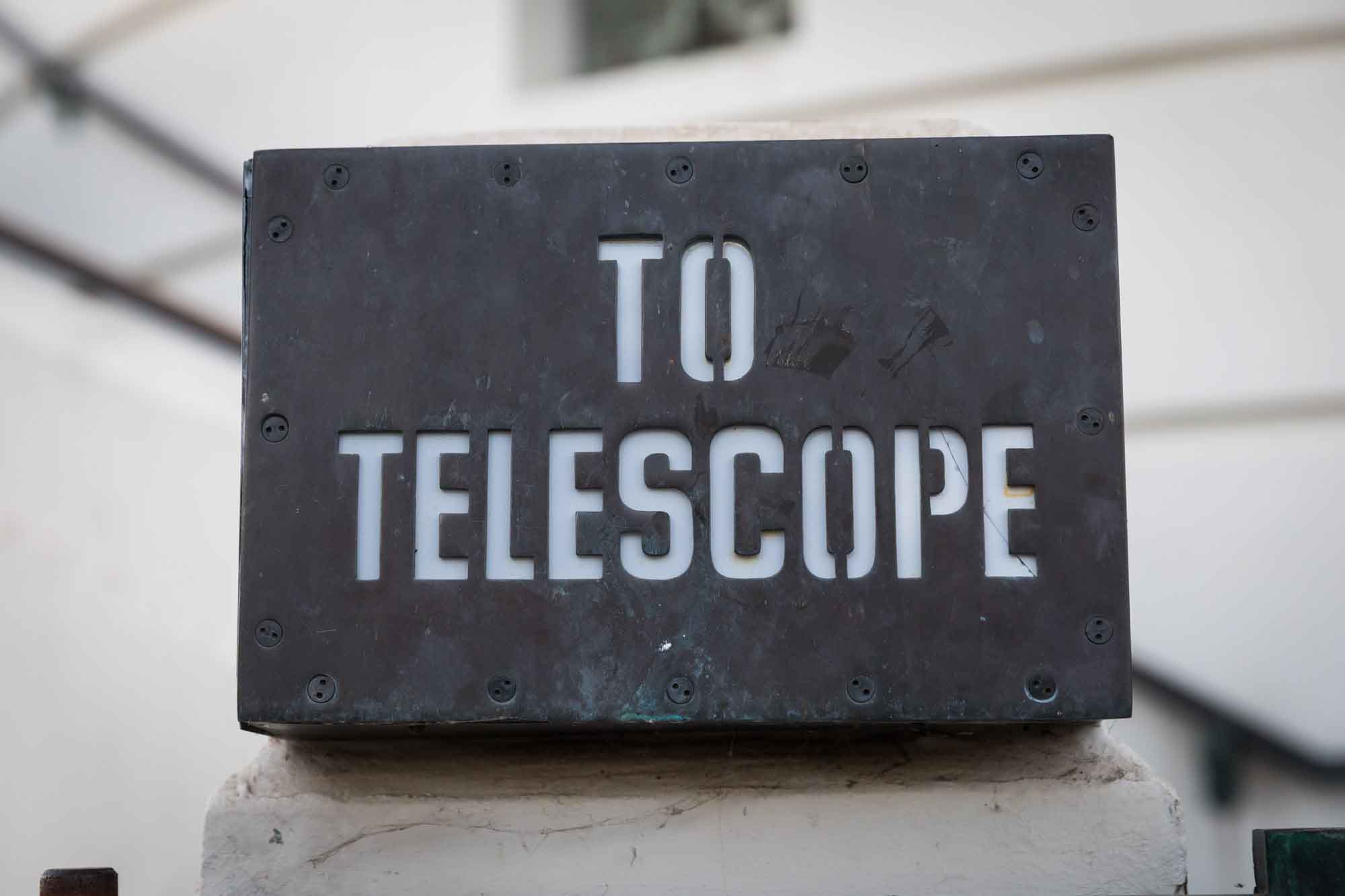 Metal sign reading 'To Telescope' for an article on where to propose at the Griffith Observatory