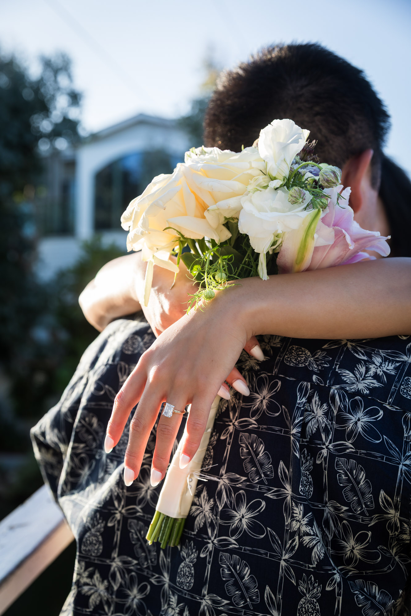 Close up of woman's hands holding bouquet of flowers and showing engagement ring on woman's hand during a Venice Canals engagement photo shoot