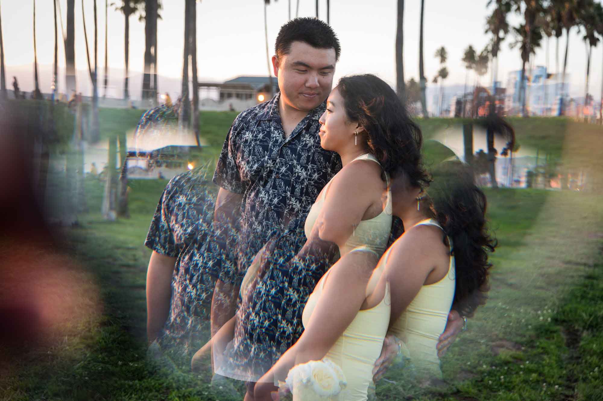 Prism photo of woman holding flower bouquet and man at sunset with palm trees in background